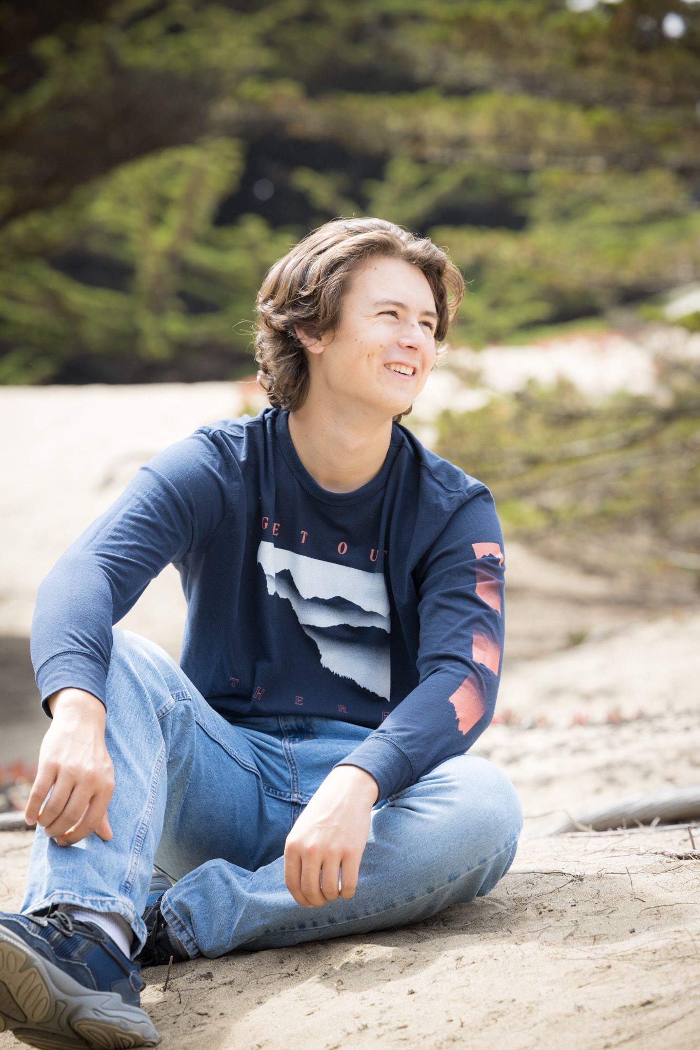 Candid beach portrait series with subject lounging on sandy slope.
