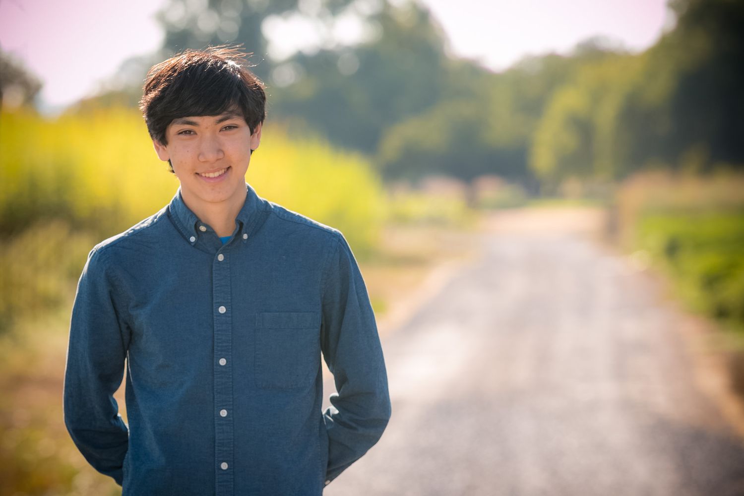 Portrait on a rural road with soft focus background and natural lighting.