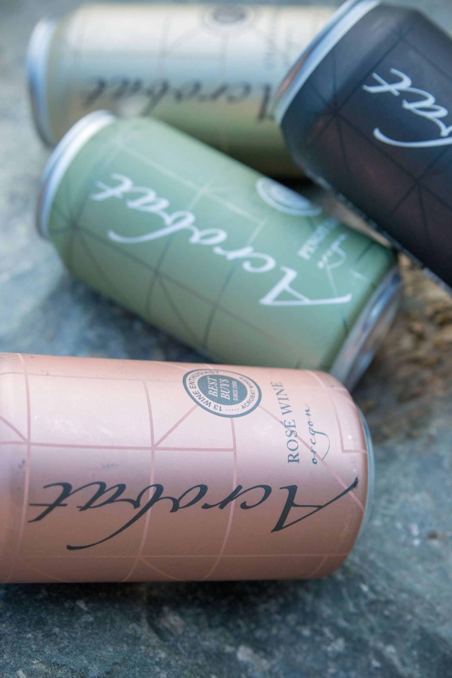 Detail shot of rose colored wine cans with artistic branding and typography.