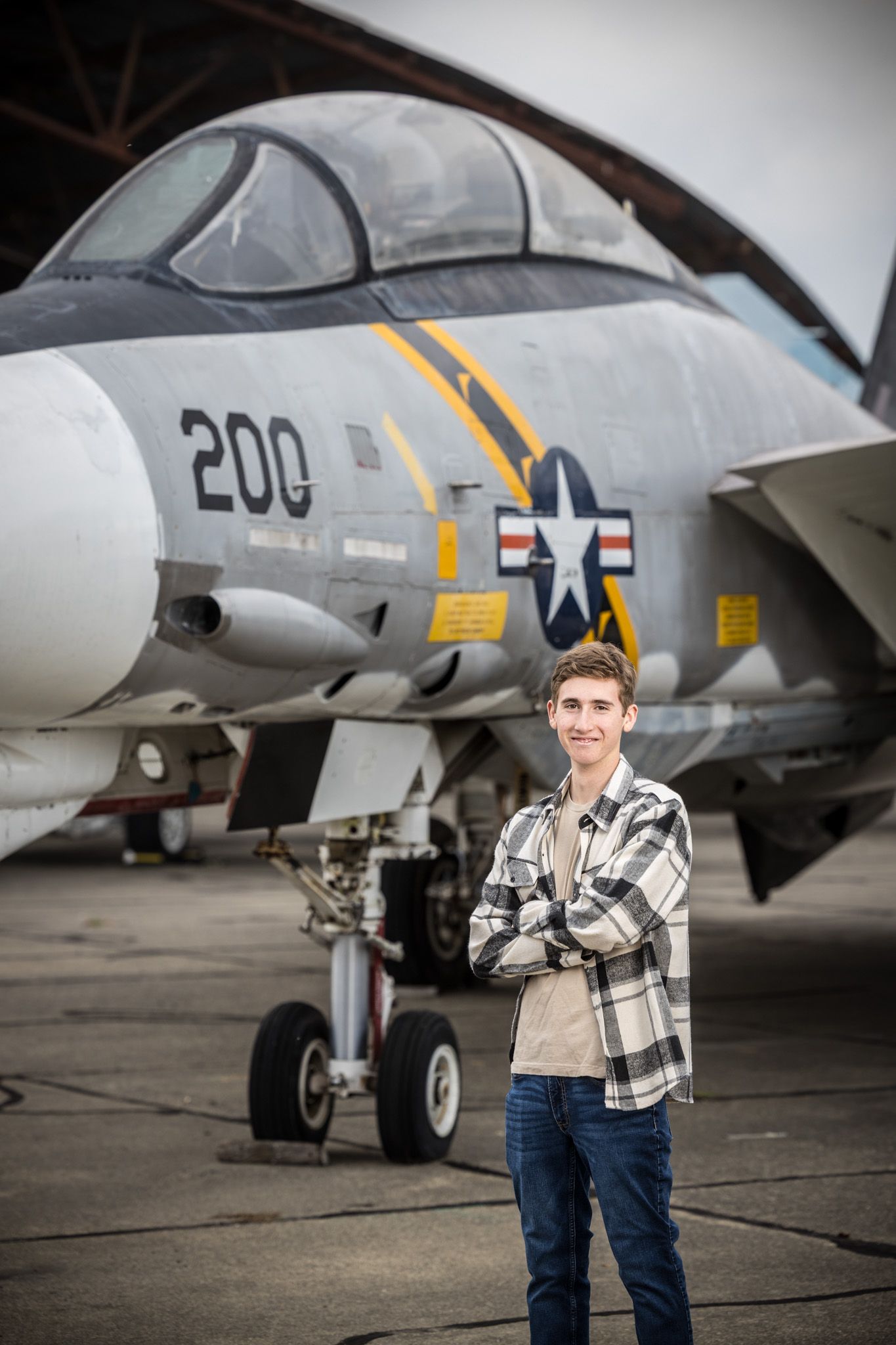 Senior Photos - Posed in front of US Navy fighter jet showing aircraft markings and nose detail.