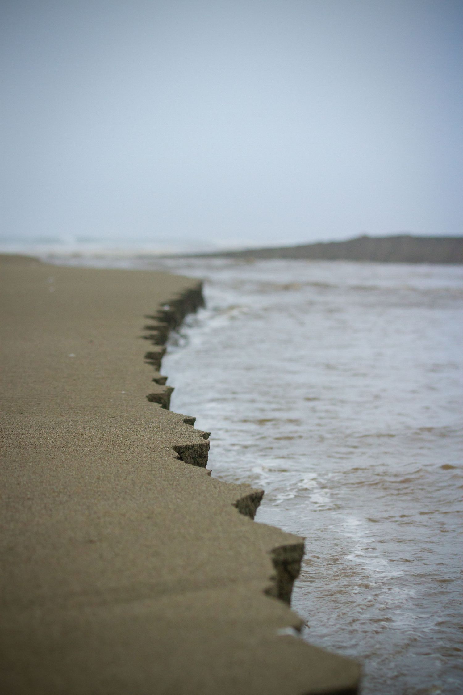 Close-up of ocean waves meeting sandy beach shore.