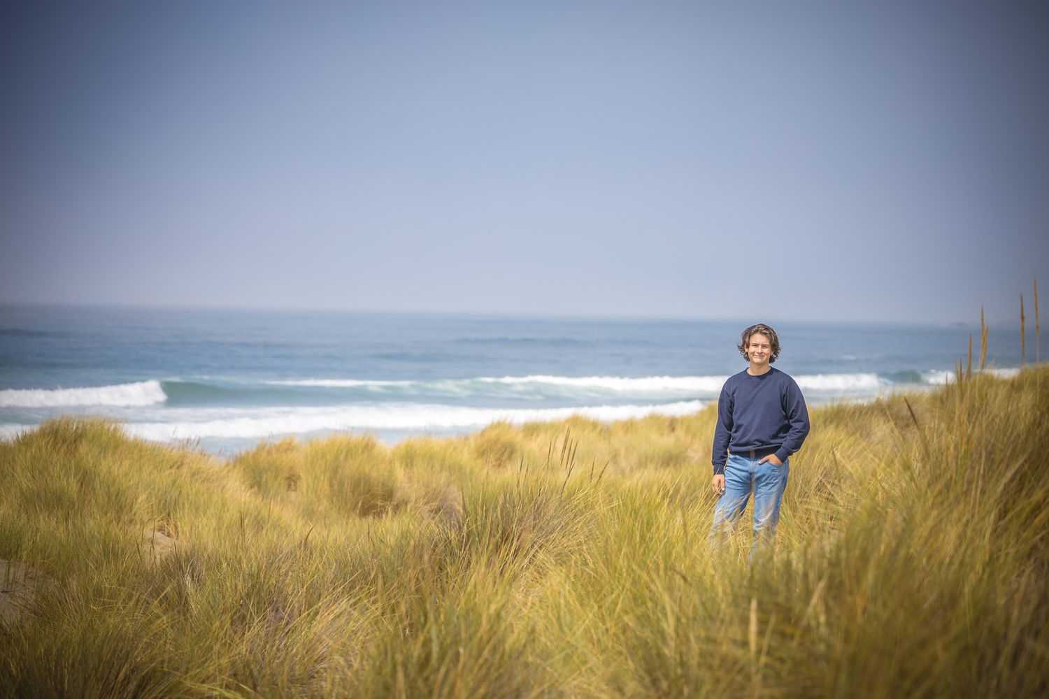 Panoramic coastal landscape with dune grass and ocean horizon.