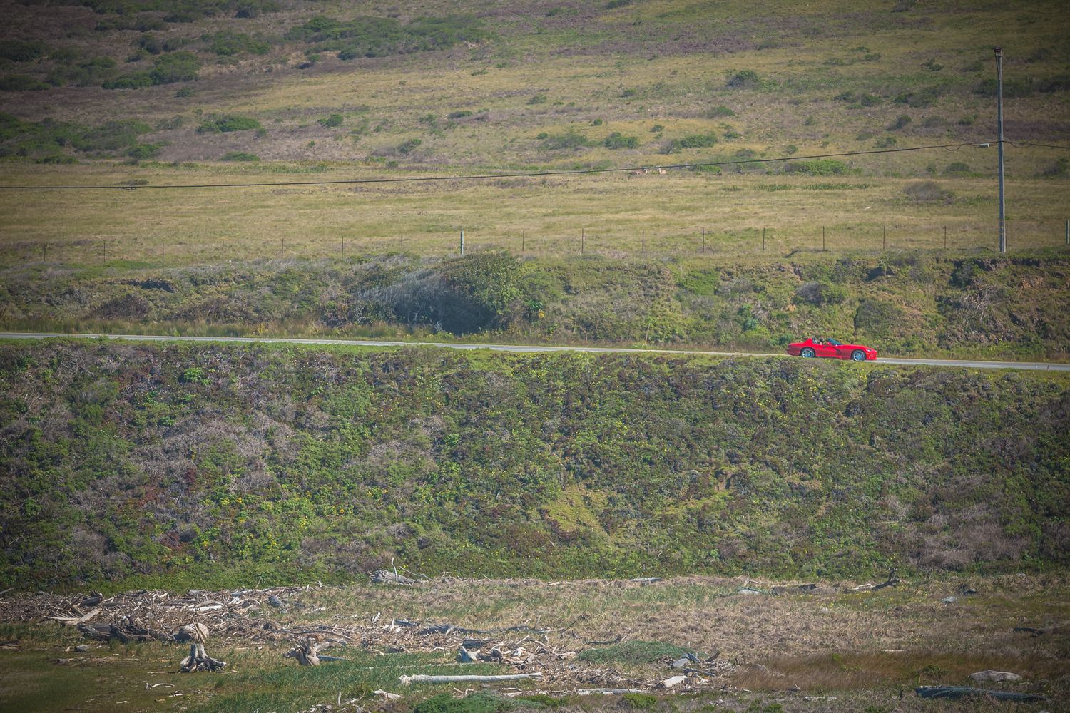 Small red structure visible on distant green hillside landscape.