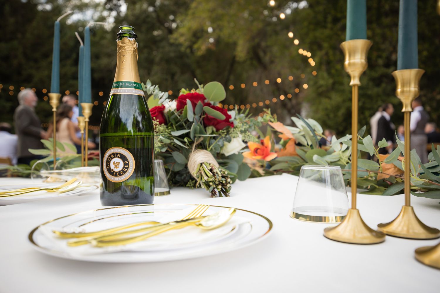 A collection of elegant table settings and decor at a wedding reception with floral centerpieces and candlelight.