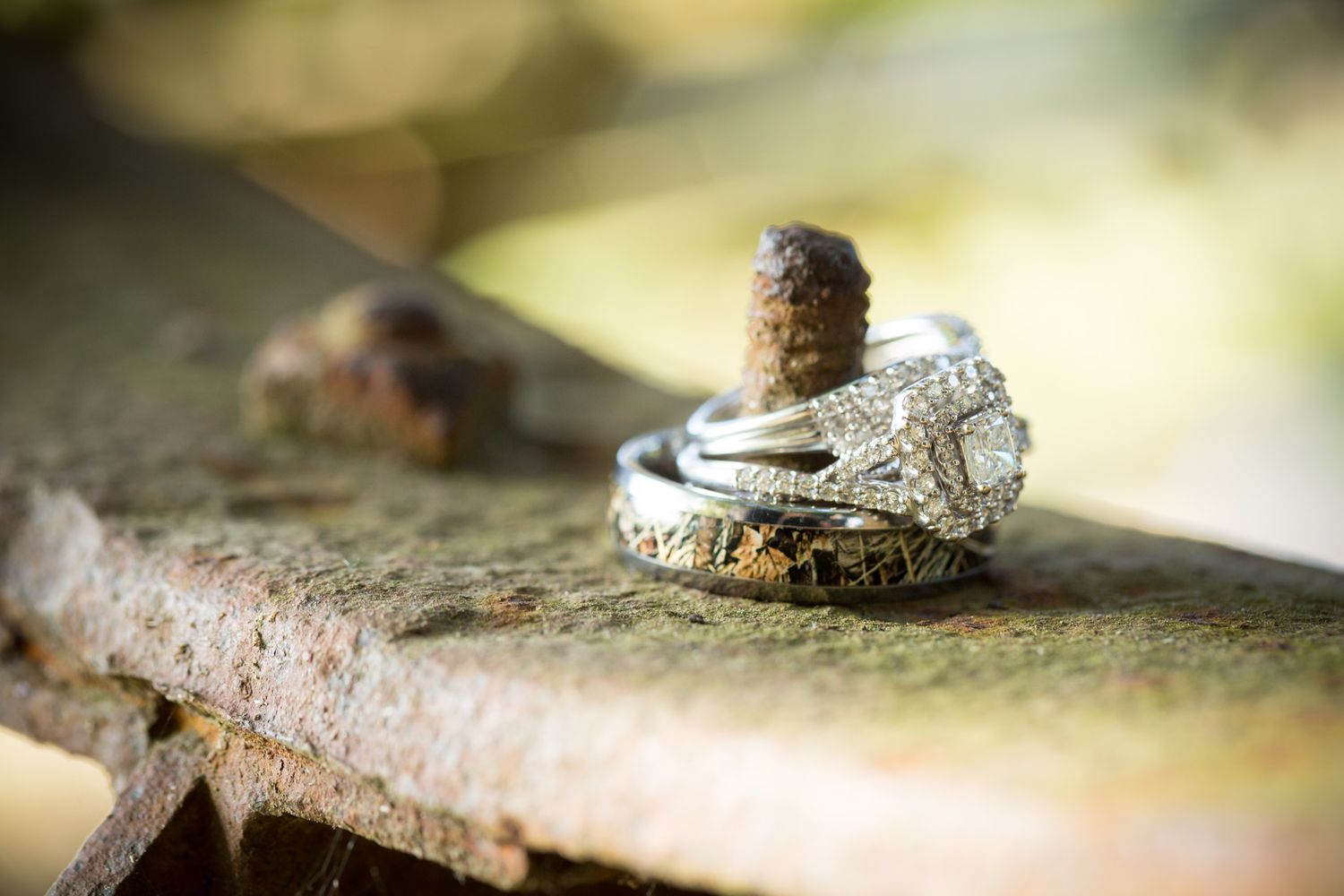 Two elegant wedding rings displayed on a rustic wooden surface in natural lighting.