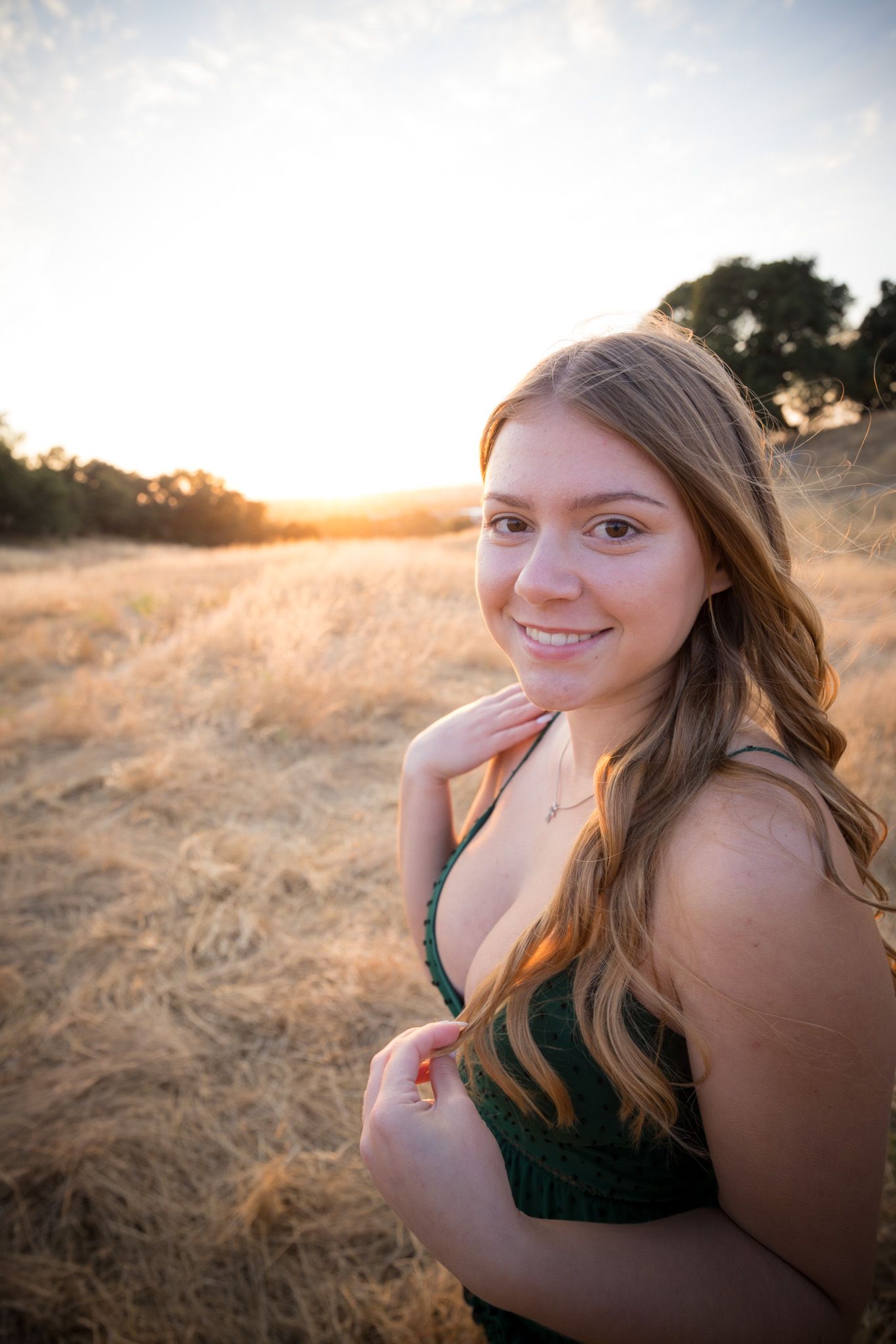 Close-up sunset portrait with warm backlighting in grassy field.