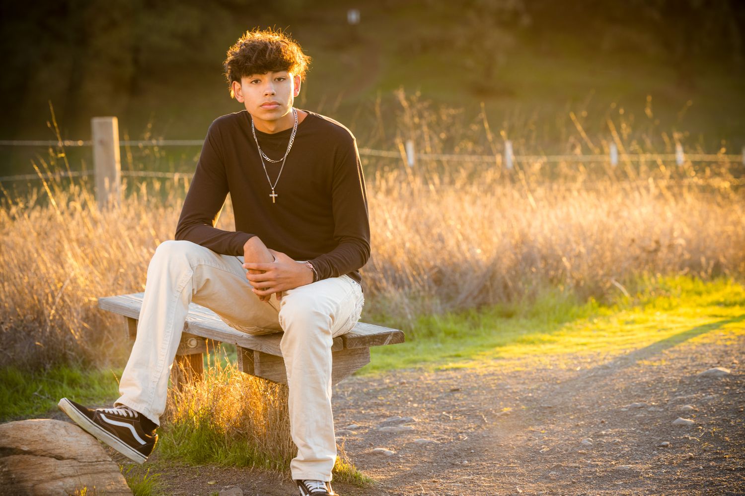 Senior Photos - Person standing on dirt path during sunset with warm natural lighting.
