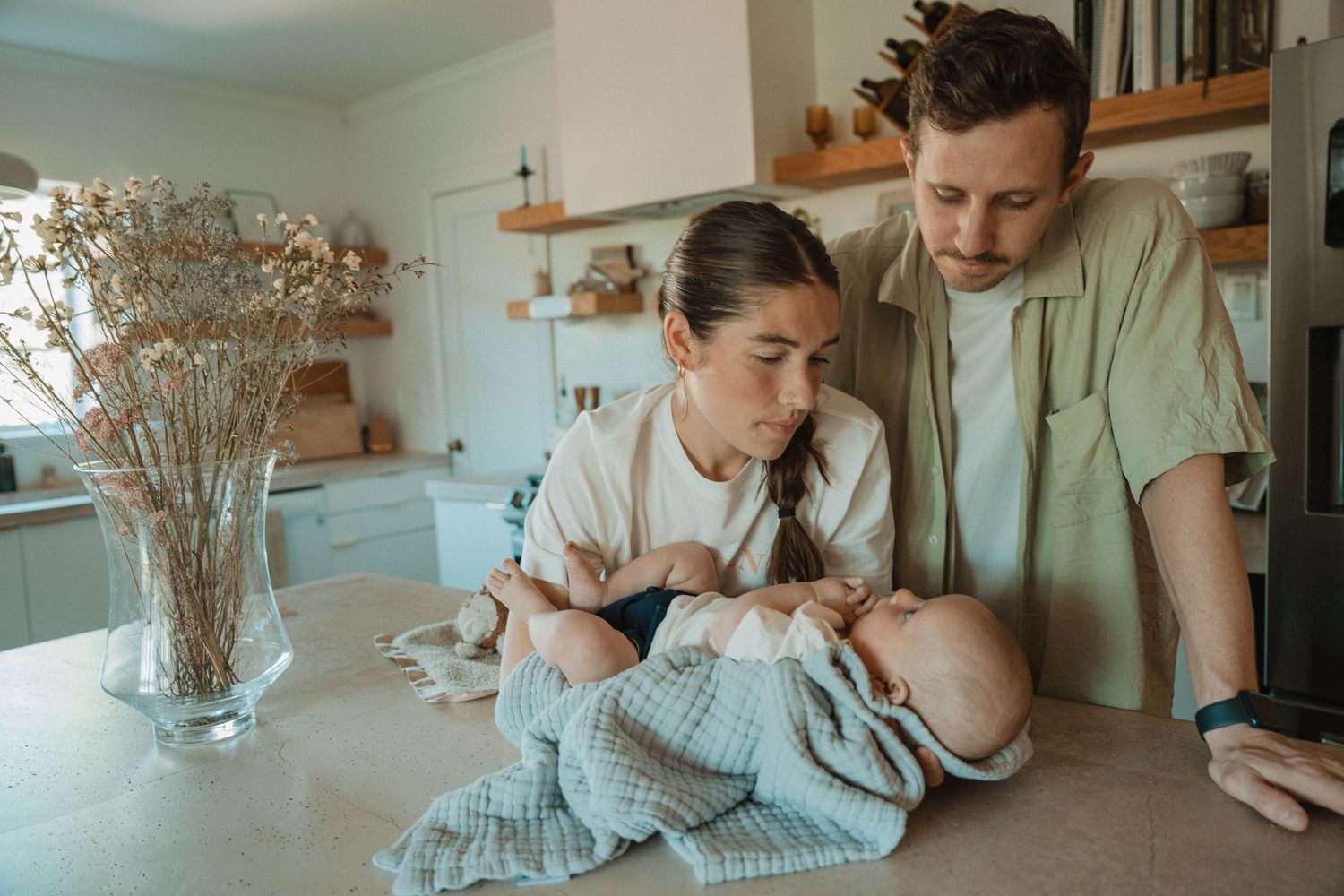 Intimate family moment captured in a bright, minimalist interior setting.