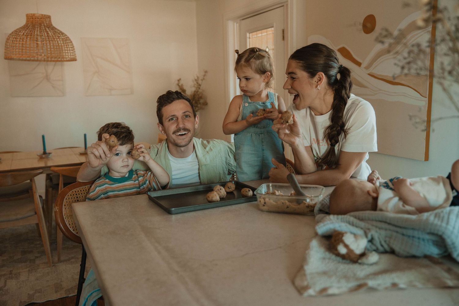 Family gathering around a wooden table sharing joyful moments together.