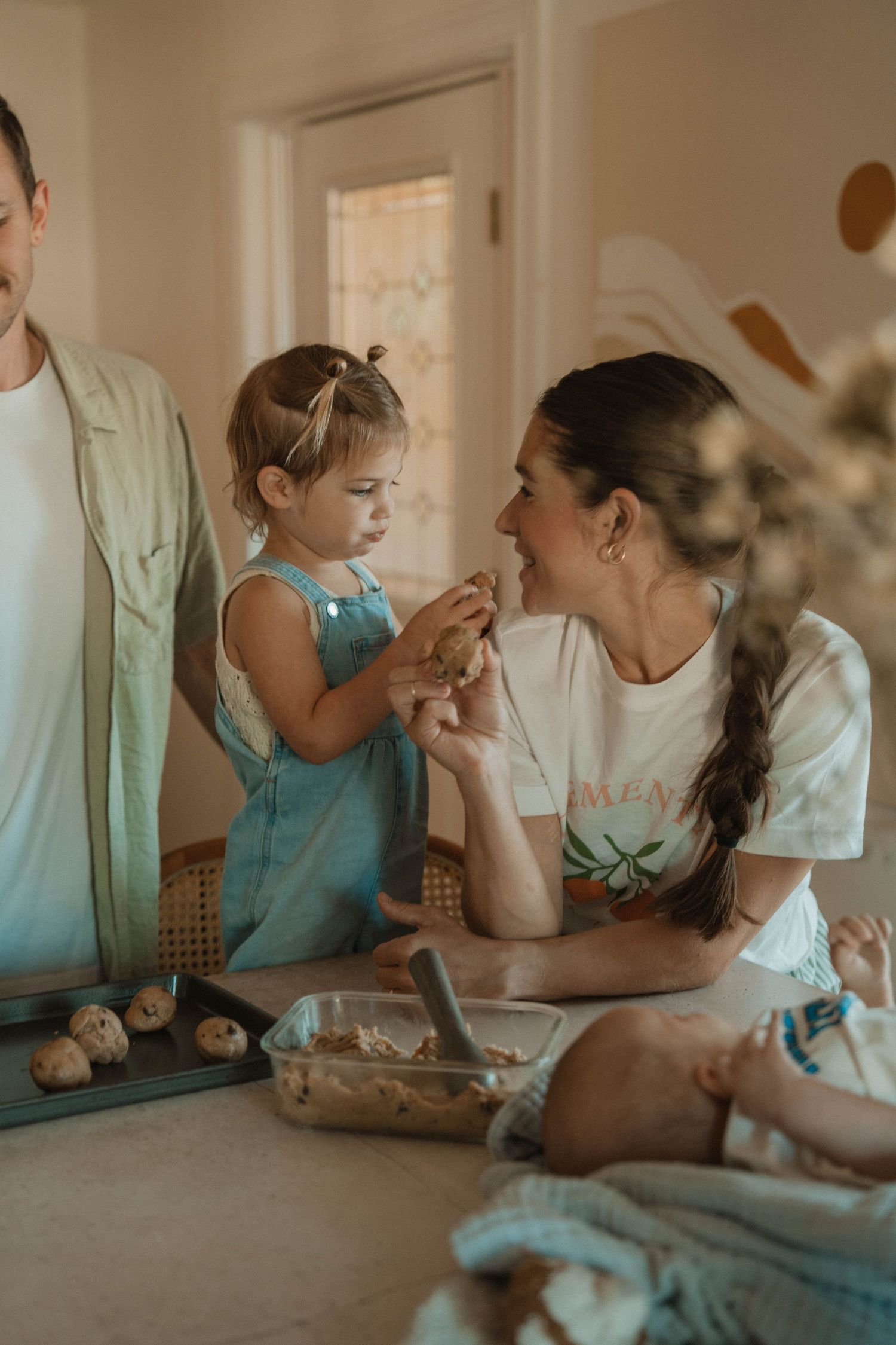 Candid family moments shared around a dining table in warm indoor lighting.