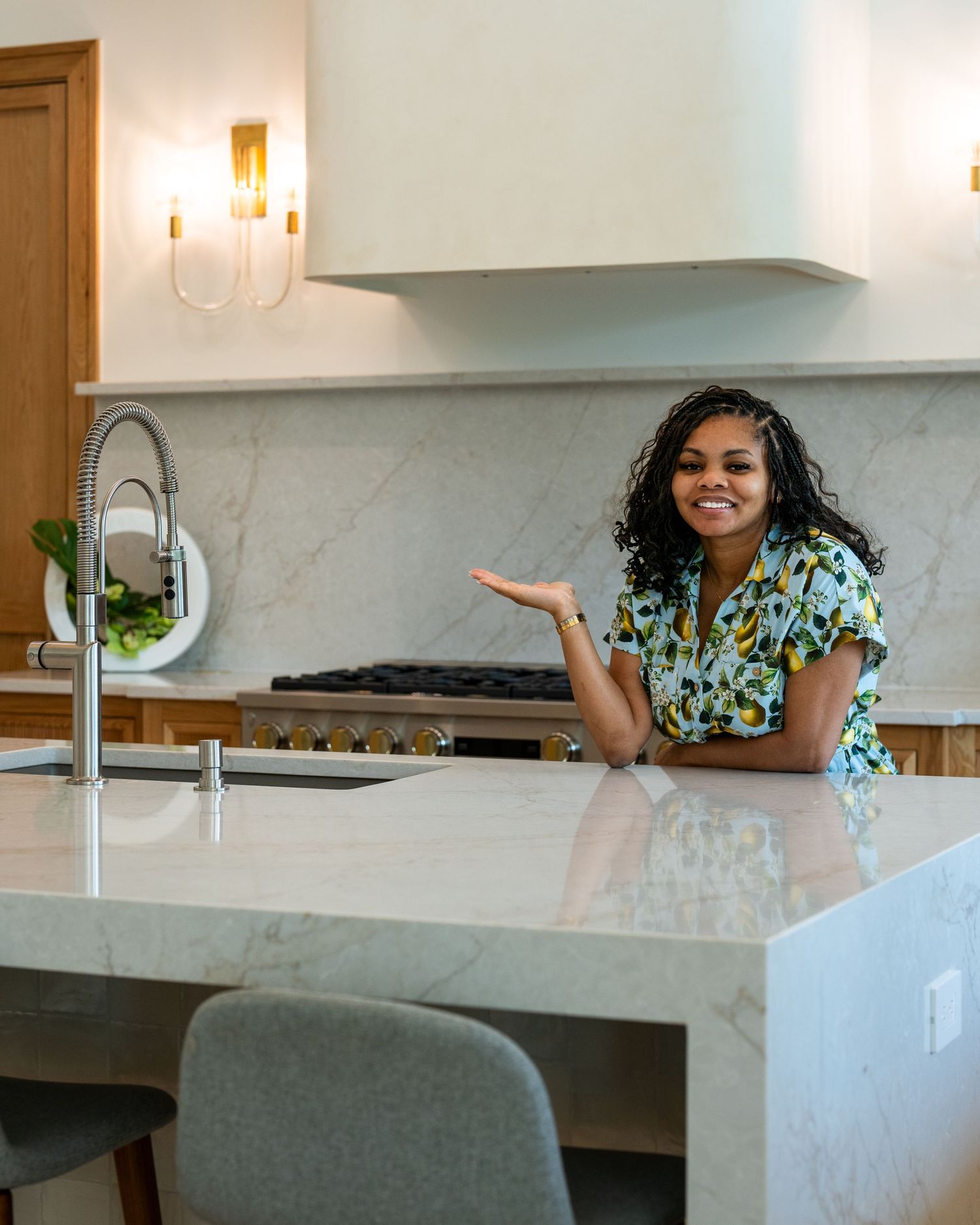 Modern kitchen interior with marble countertop, wooden cabinets and bright natural lighting.