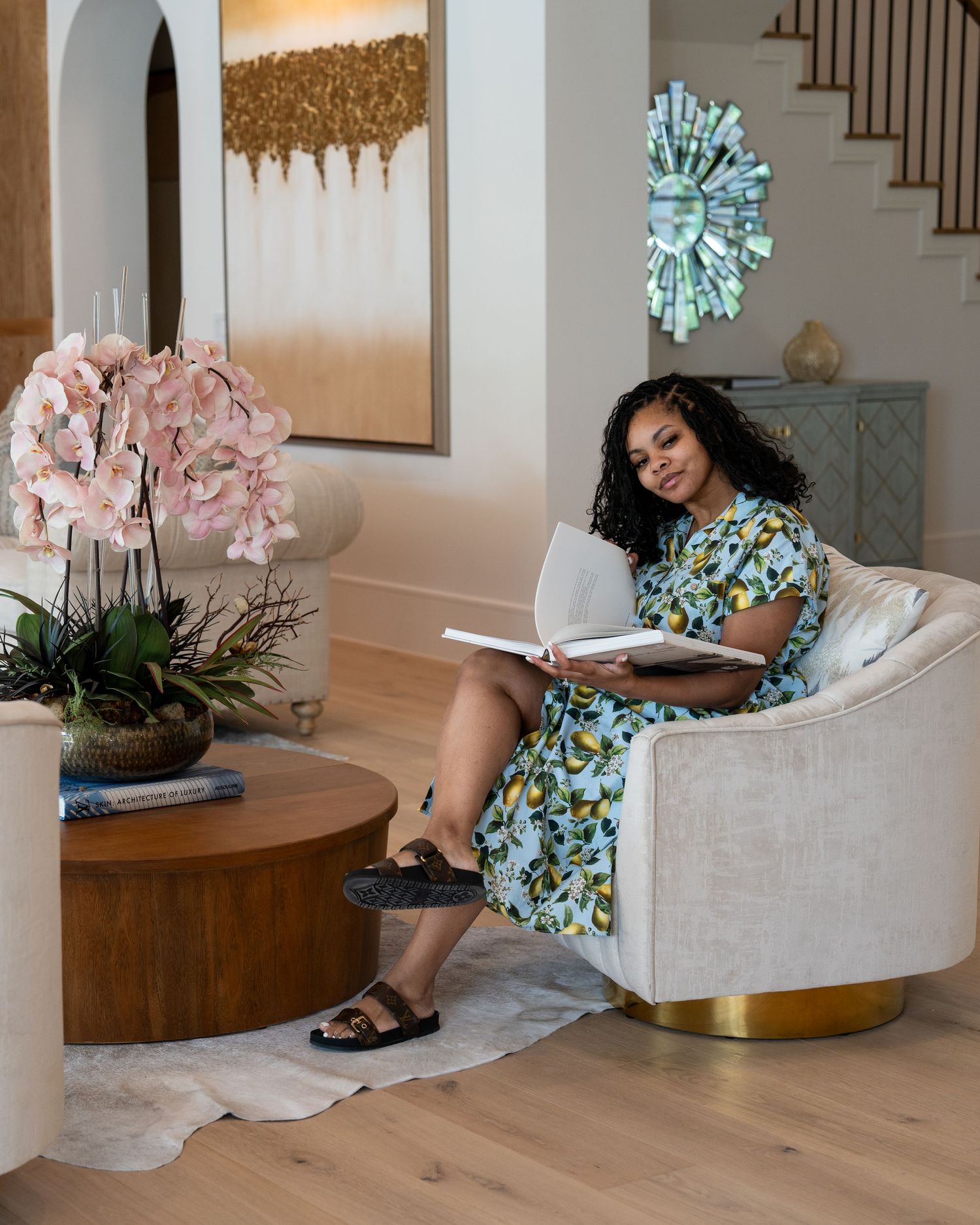 Cozy reading nook with plush white chair, wooden coffee table, and pink floral arrangement.