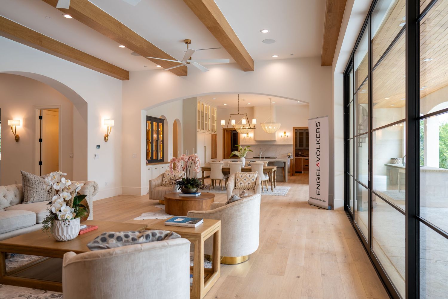 Modern open-plan living space with wooden beams, large windows, and contemporary furniture.