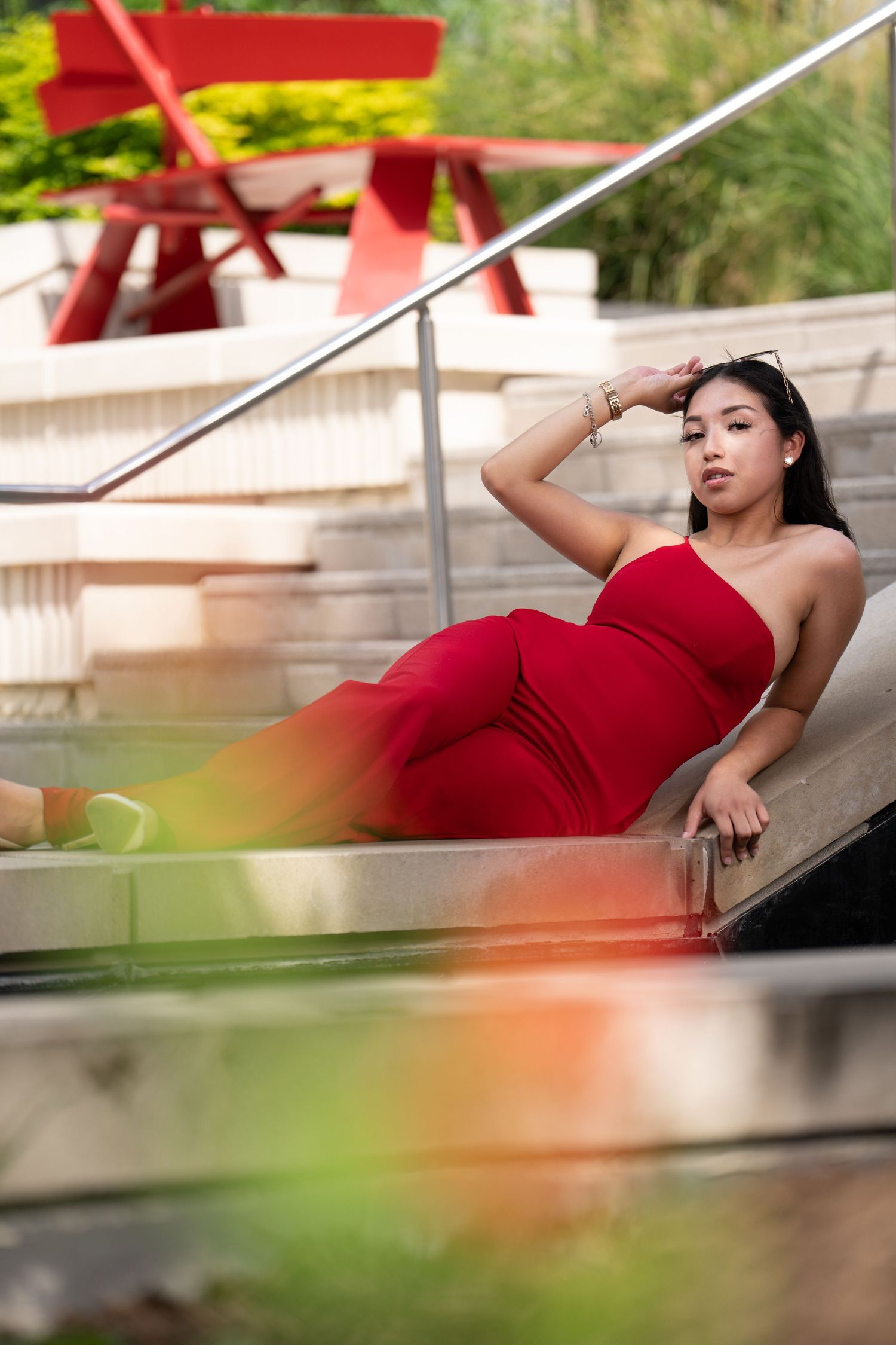 Fashion portrait on steps with red picnic table in background.
