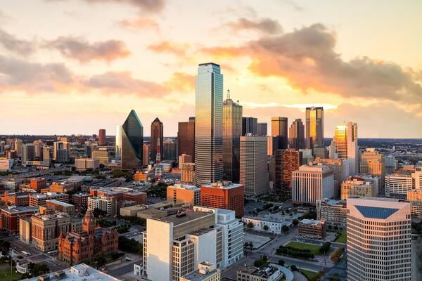 Downtown Dallas cityscape during golden hour with iconic skyscrapers.
