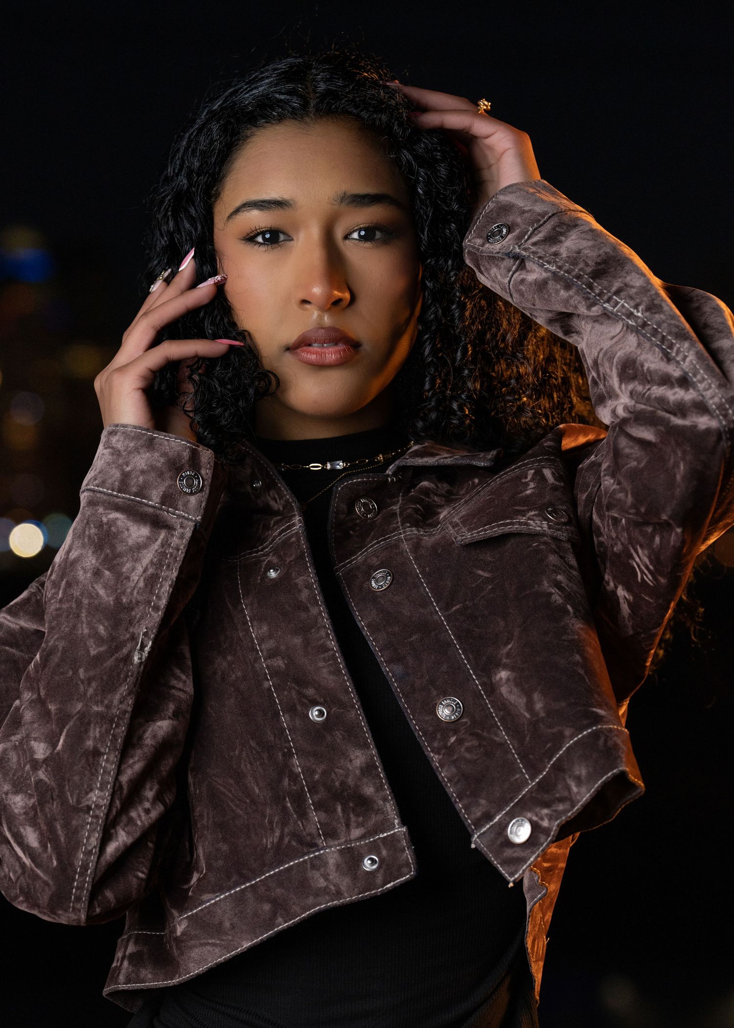 Close-up portrait of a woman at night with the Dallas skyline at Margaret Hunt Hill Bridge in Dallas, Texas, captured by DFW Dynamic Media.