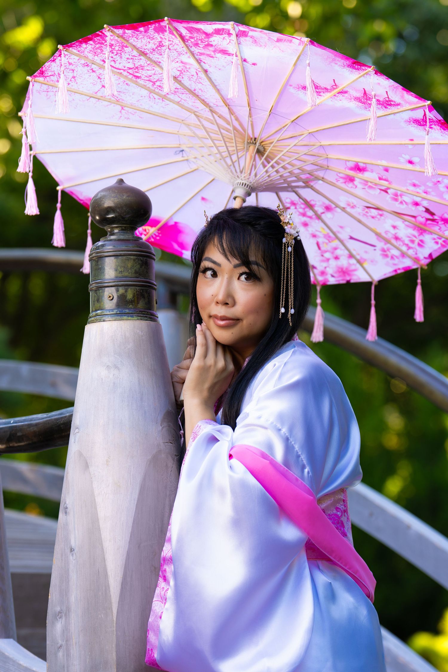 Outdoor portrait of woman with pink parasol on bridge in Japanese Garden, Fort Worth Botanic Garden, Texas by DFW Dynamic Media