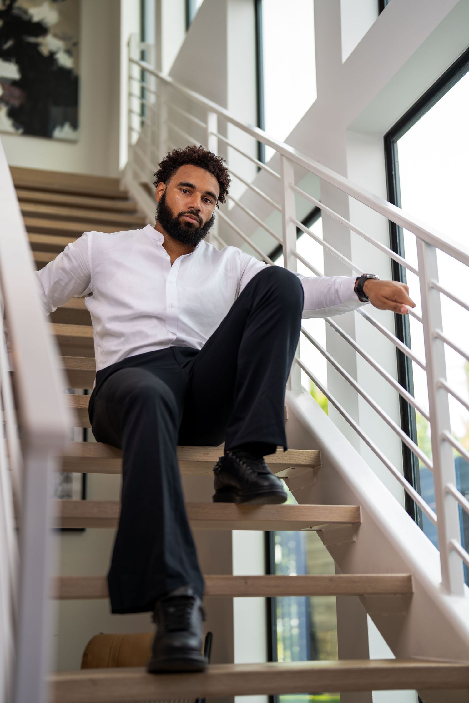 Modern business casual portrait on contemporary staircase with metal railings.