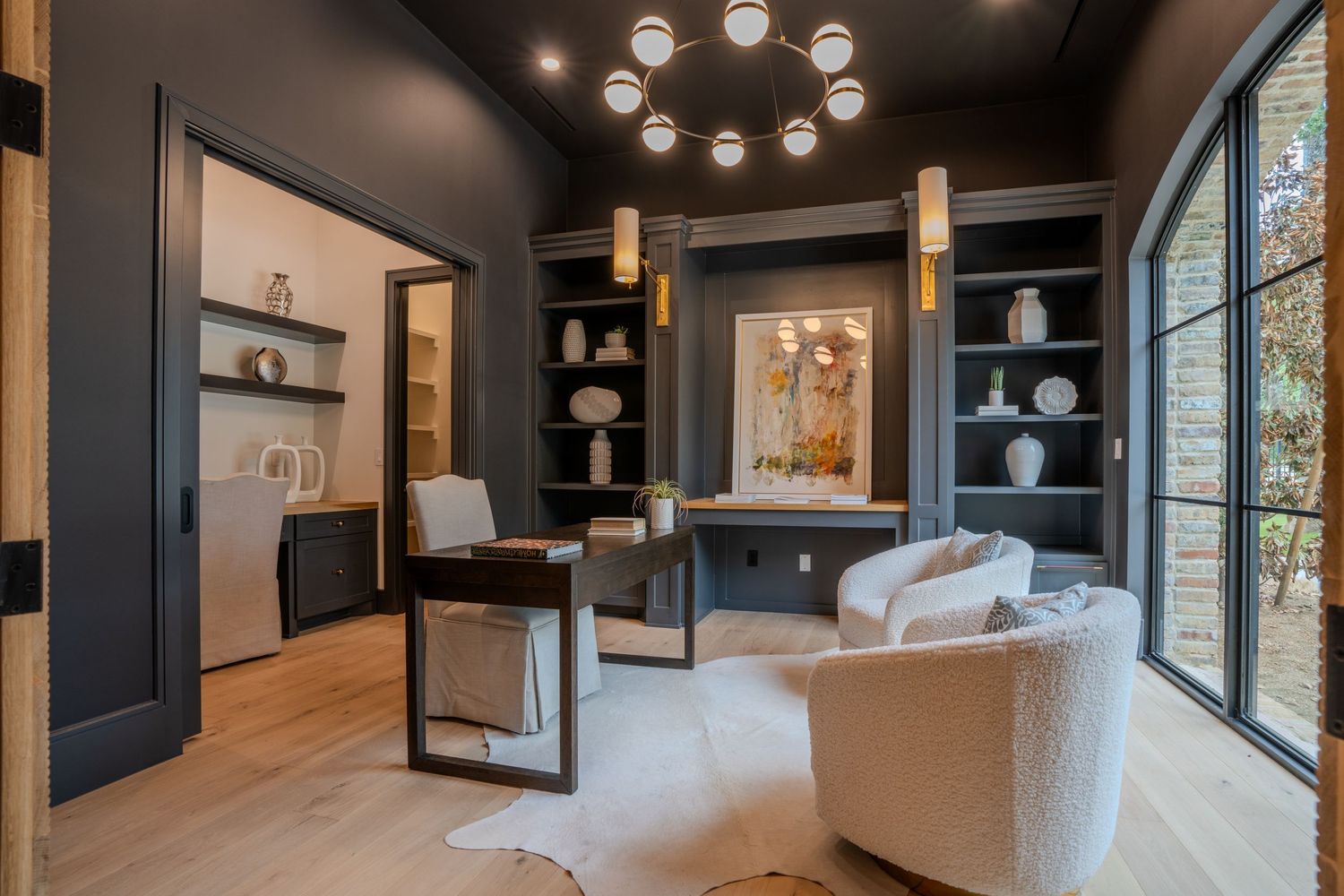 Contemporary office space with dark walls, modern lighting and comfortable seating area.