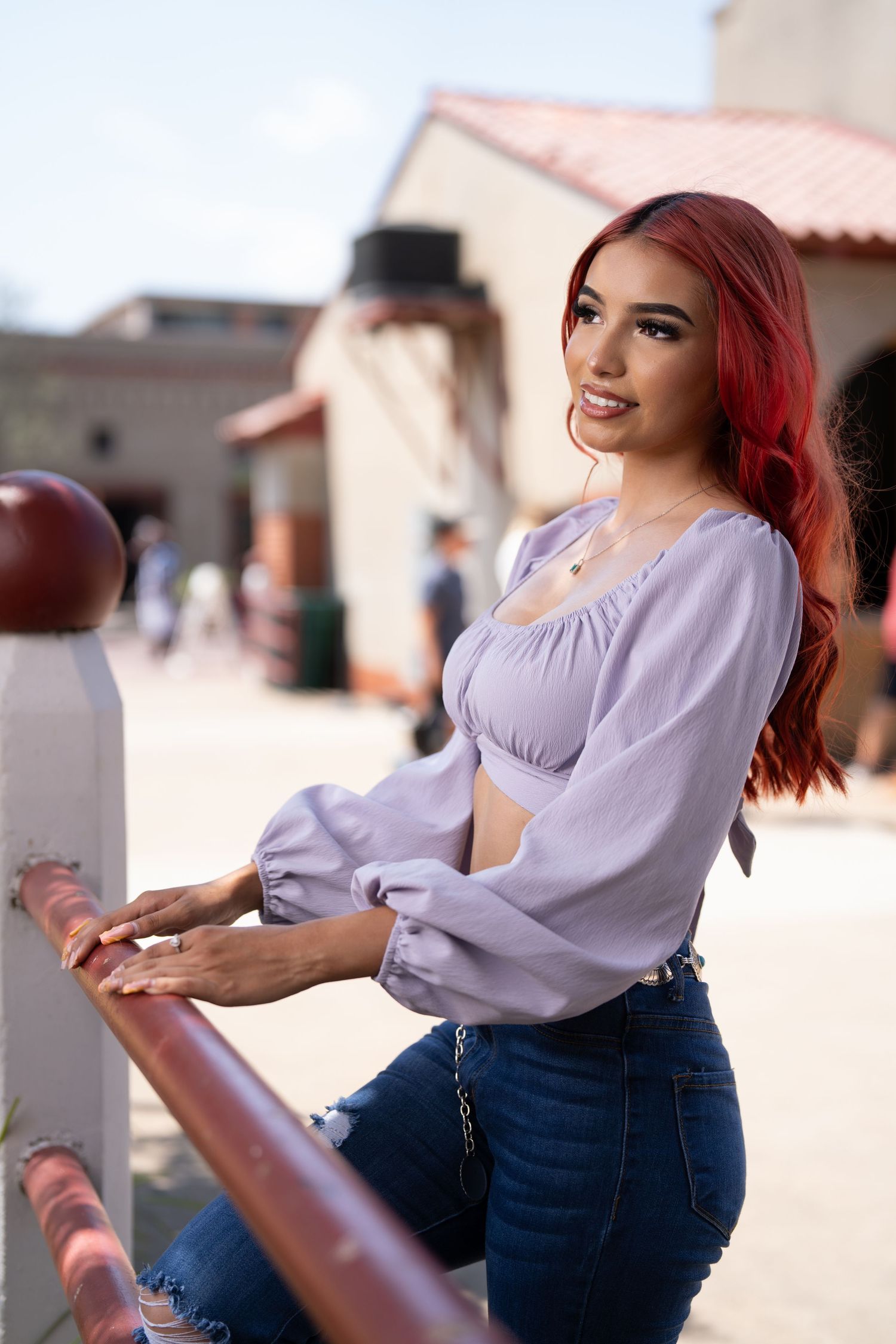 Stylish outfit featuring purple puff sleeve crop top and concho belt against Spanish architecture.