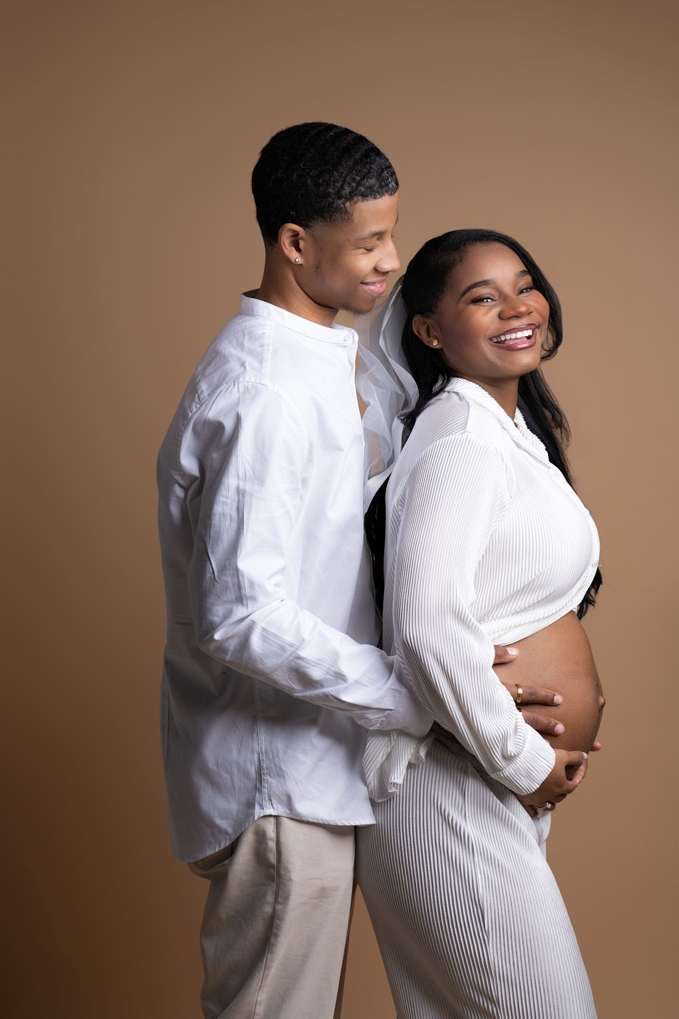 Expecting couple embracing during studio maternity photo session, — intimate pregnancy portrait in Dallas Texas