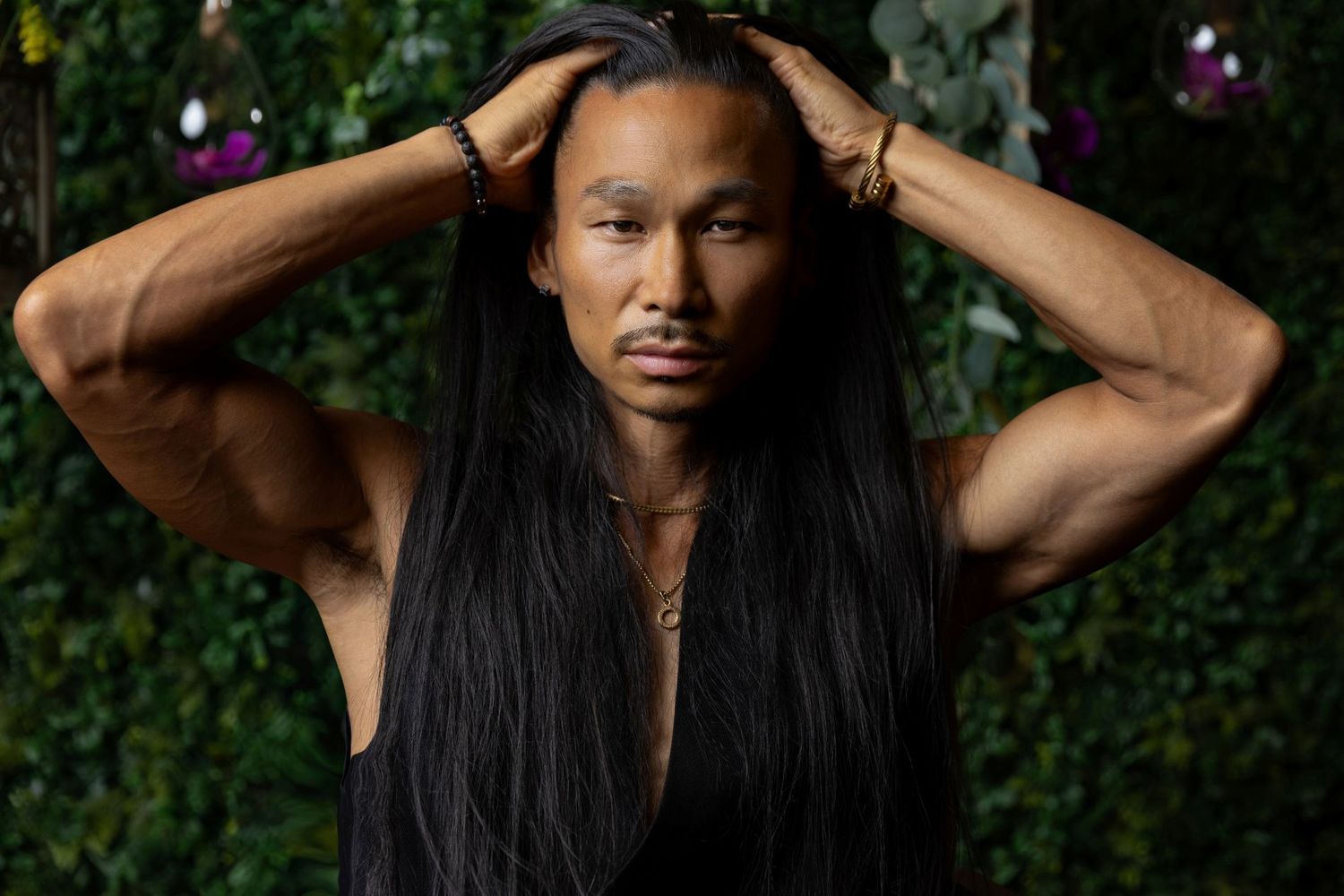 Artistic outdoor portrait series with flowing dark hair against natural backdrop.