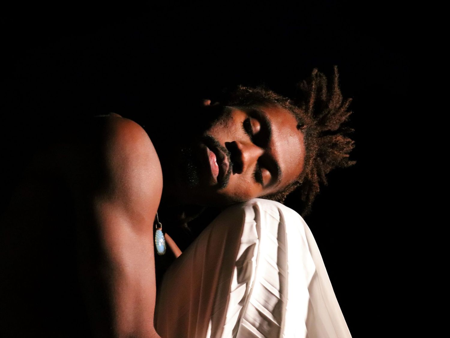 Dramatic dance portrait with stark lighting and shadows with male dancer