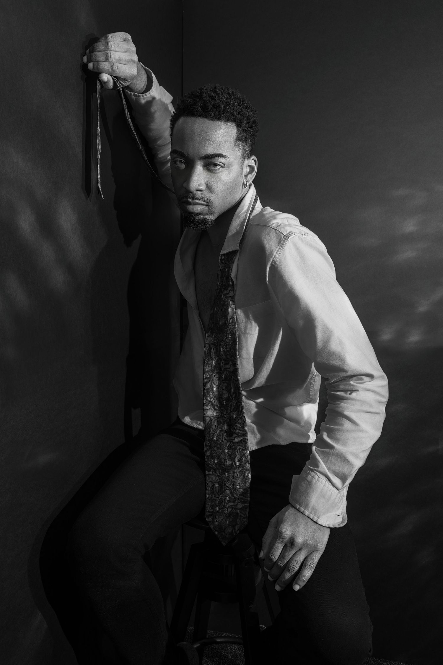Dramatic black and white portrait series showing artistic poses in formal attire.