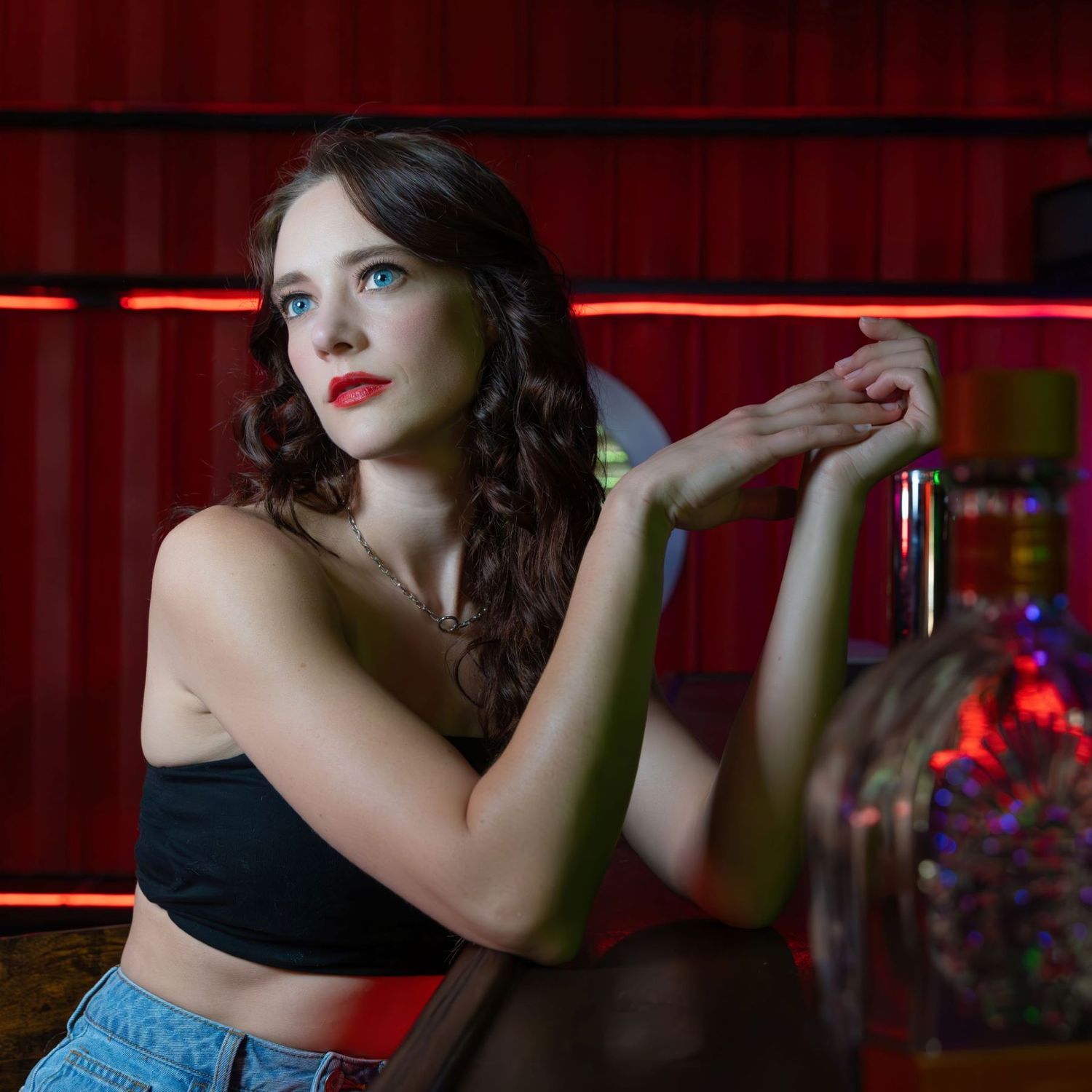 Atmospheric bar photoshoot series with moody red lighting and retro aesthetic.