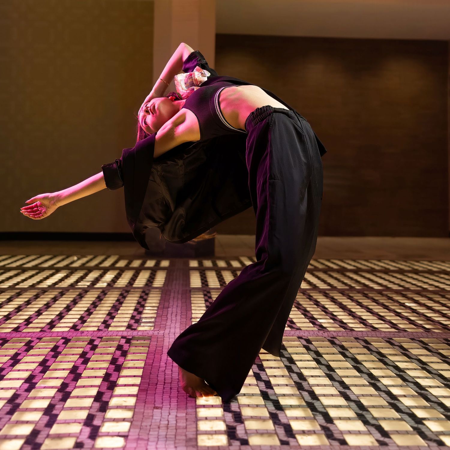 Dance performance showing intricate footwork on a patterned floor with dramatic lighting.