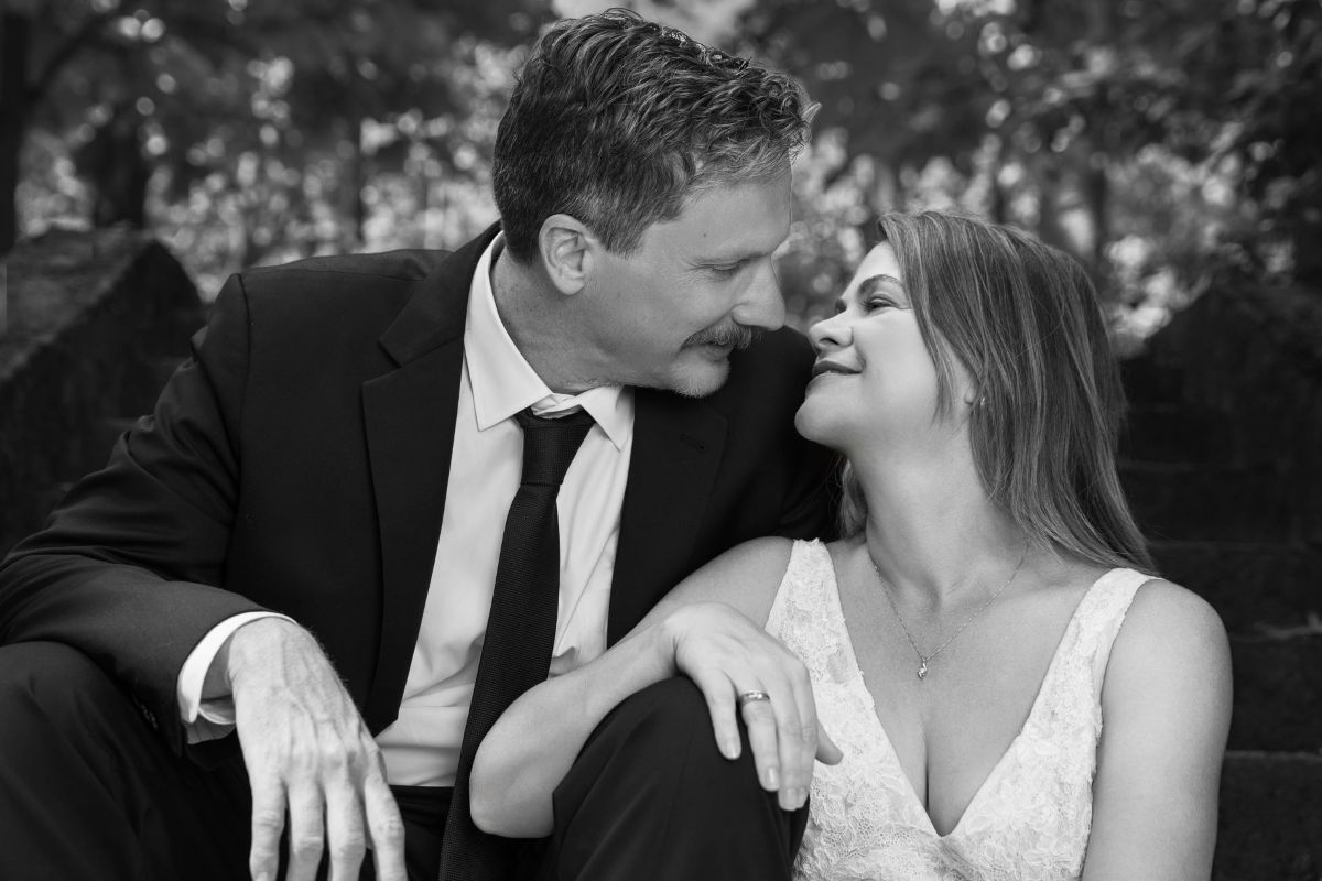 A romantic black and white wedding photo collage showing intimate moments between newlyweds in an outdoor setting.