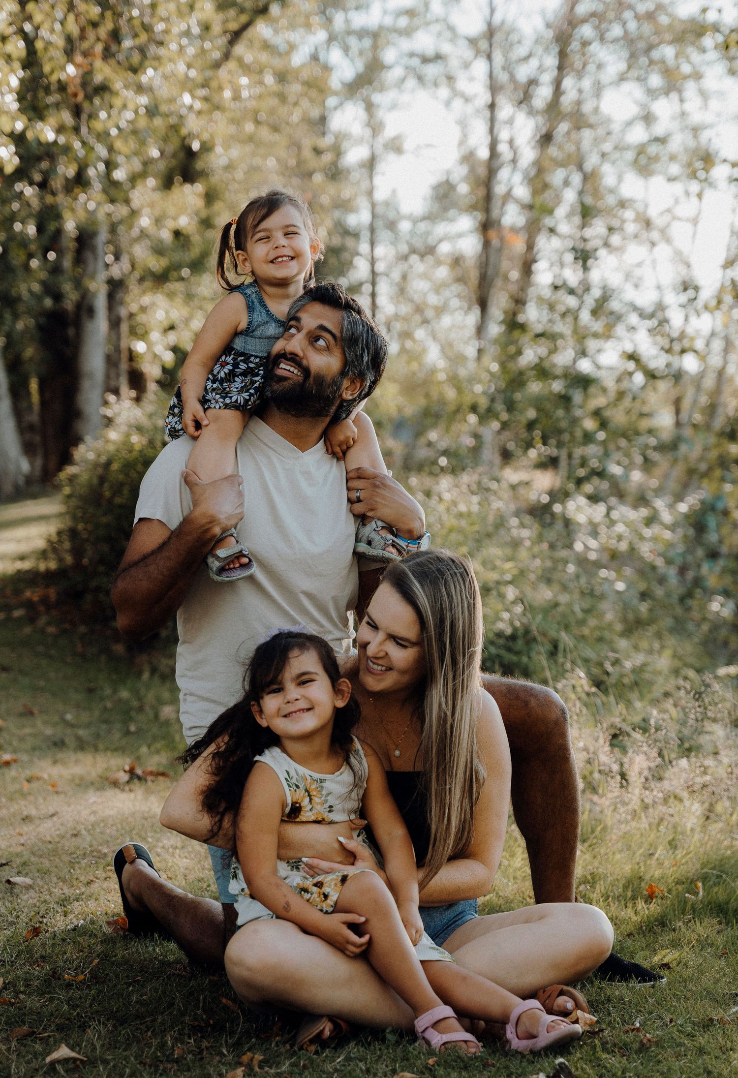 Family enjoying a tender moment together outdoors on a sunny day in a natural wooded setting.
