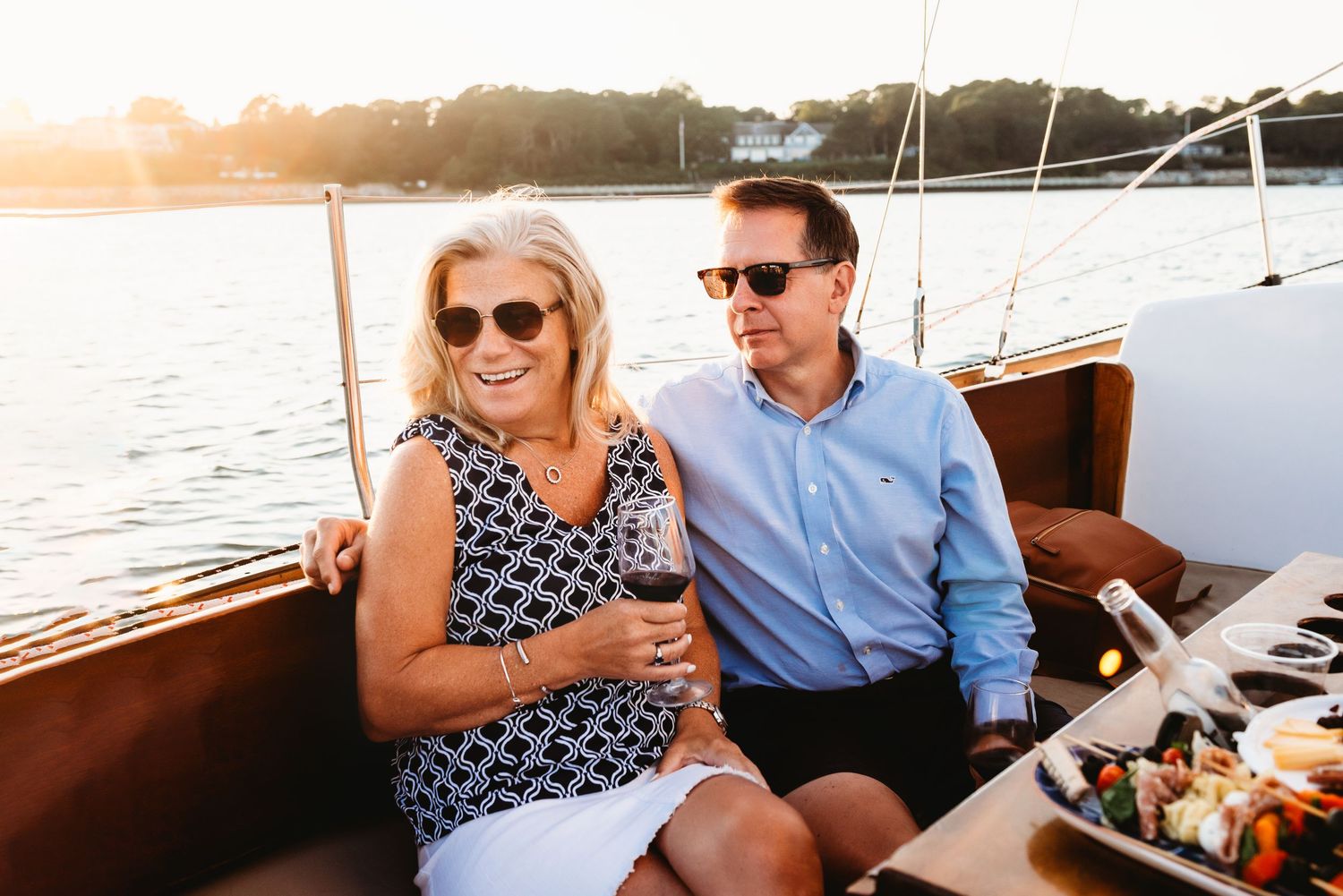 Couple enjoying wine together on a sailboat at sea.