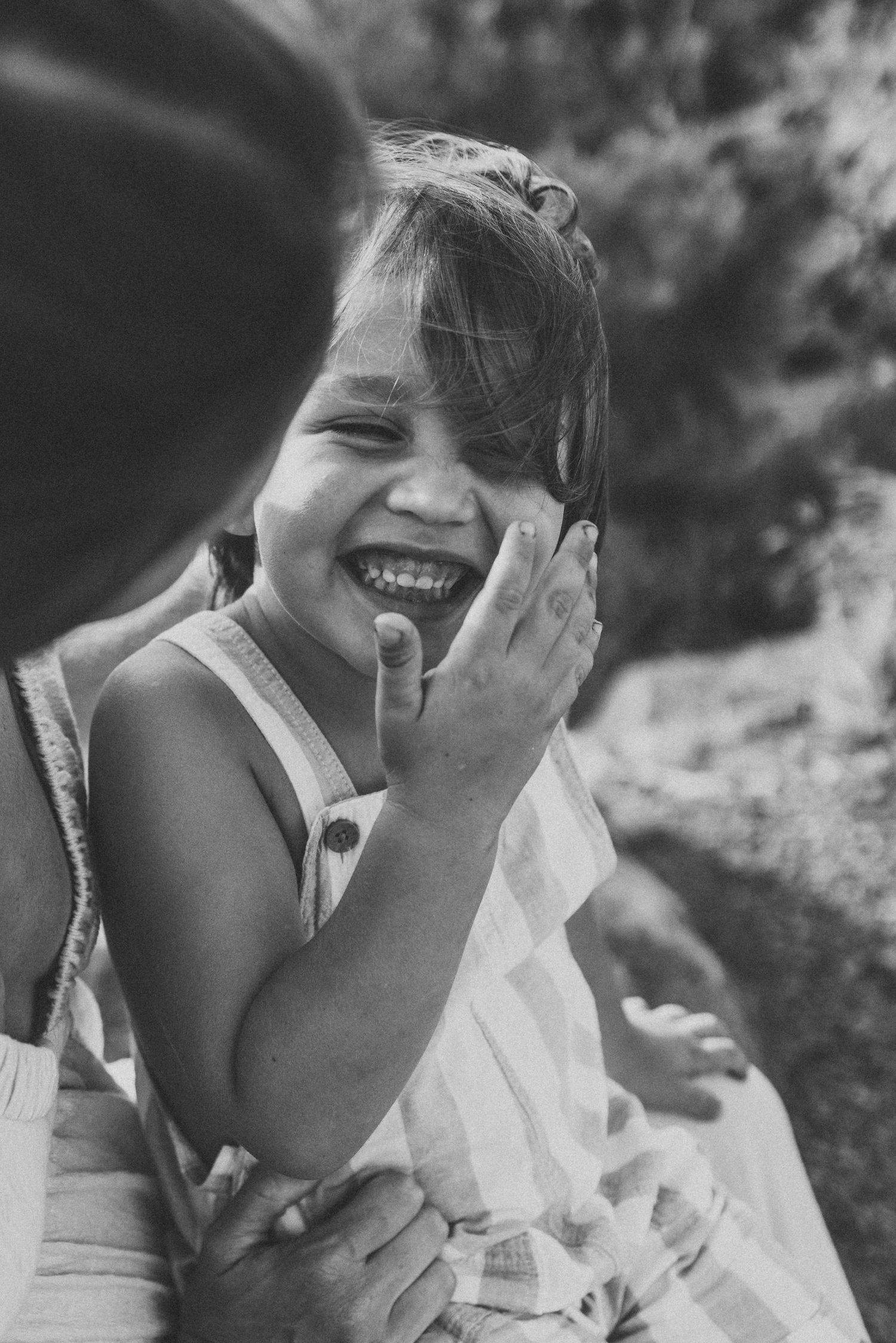 Candid black and white photo of mom and kid laughing together by Maui photographer.