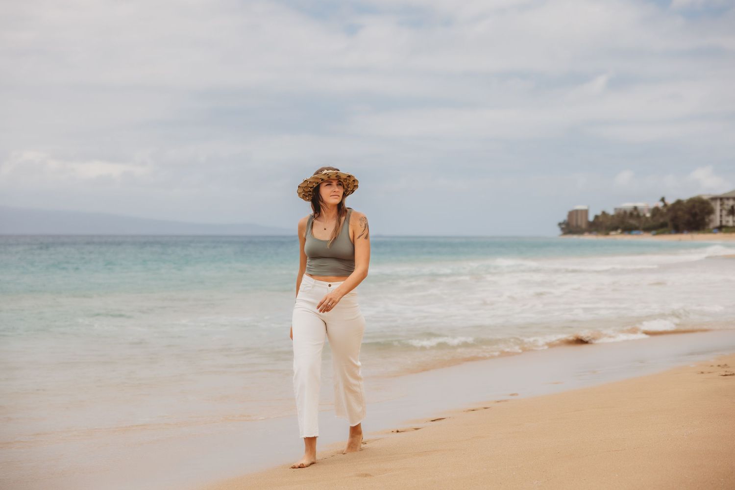 Lifestyle brand image featuring a woman strolling by the sea.
