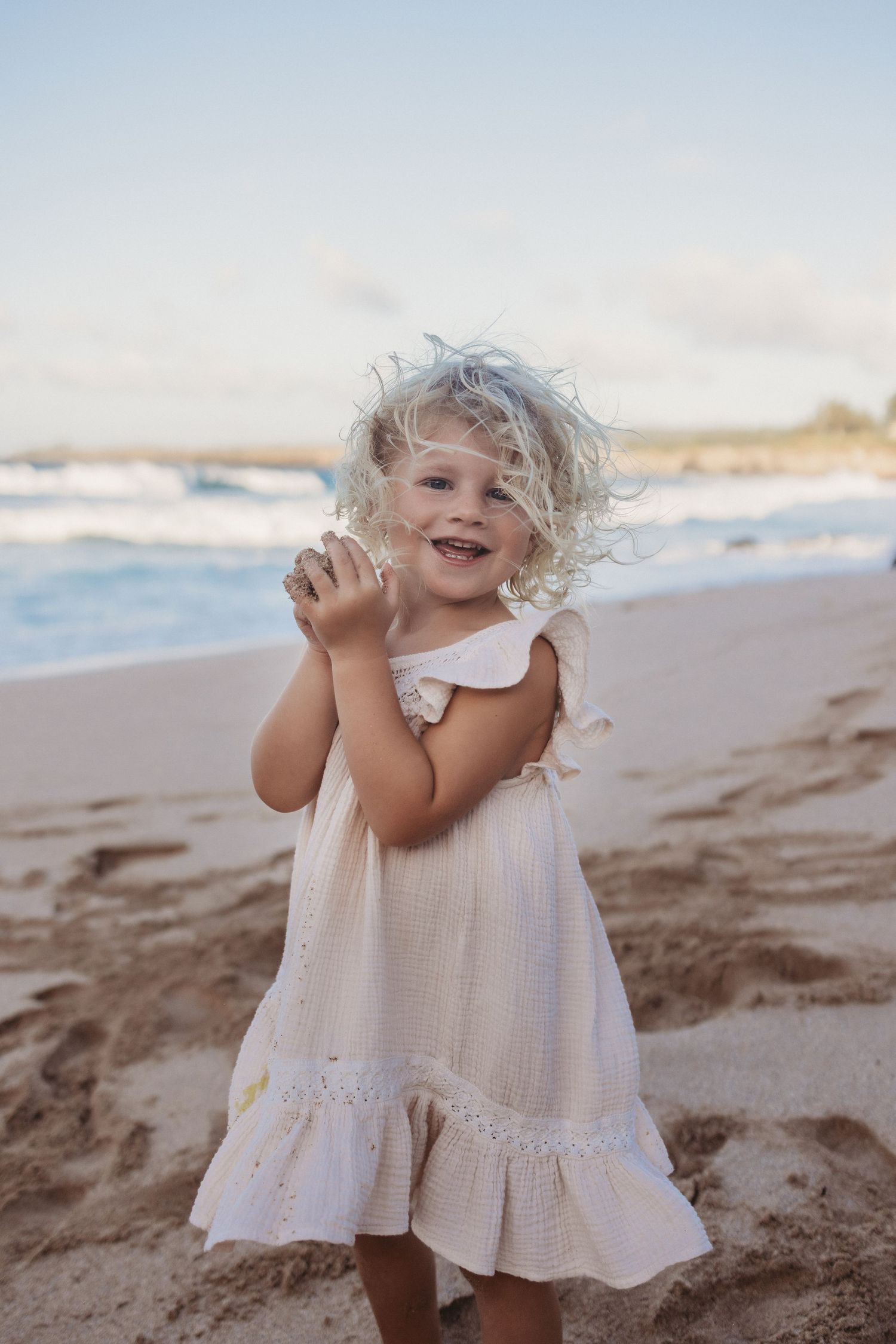 Maui lifestyle photographer captures girl smiling joyfully on the shoreline.