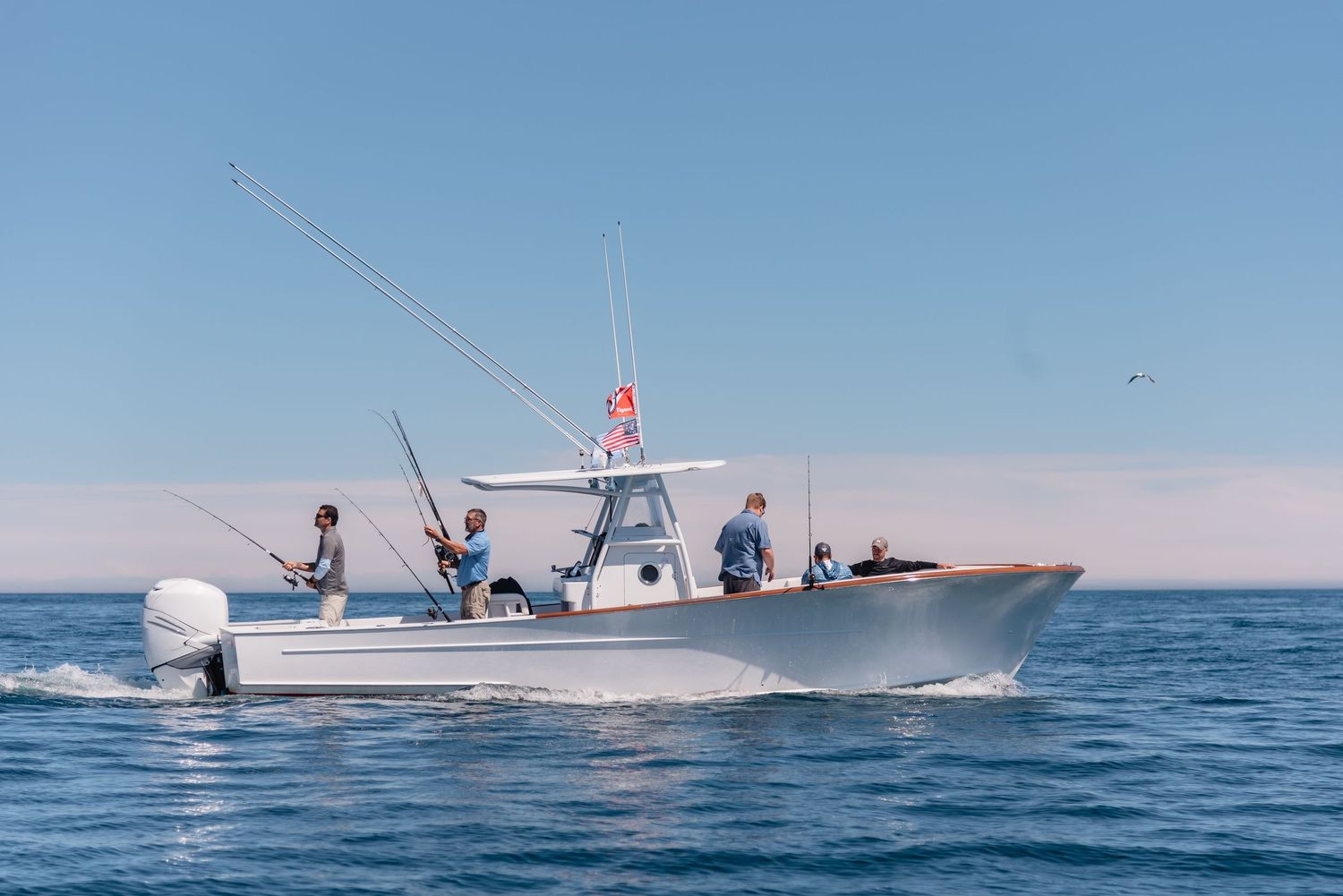 Group of men casting lines from a boat in the ocean.