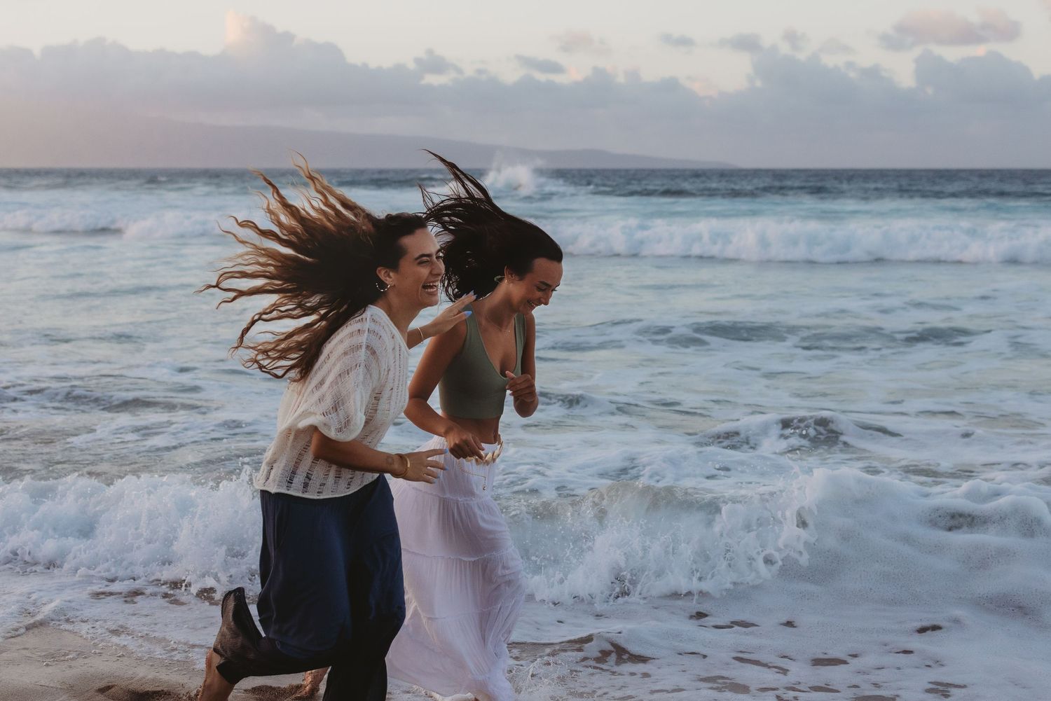 sisters running on beach in Maui.