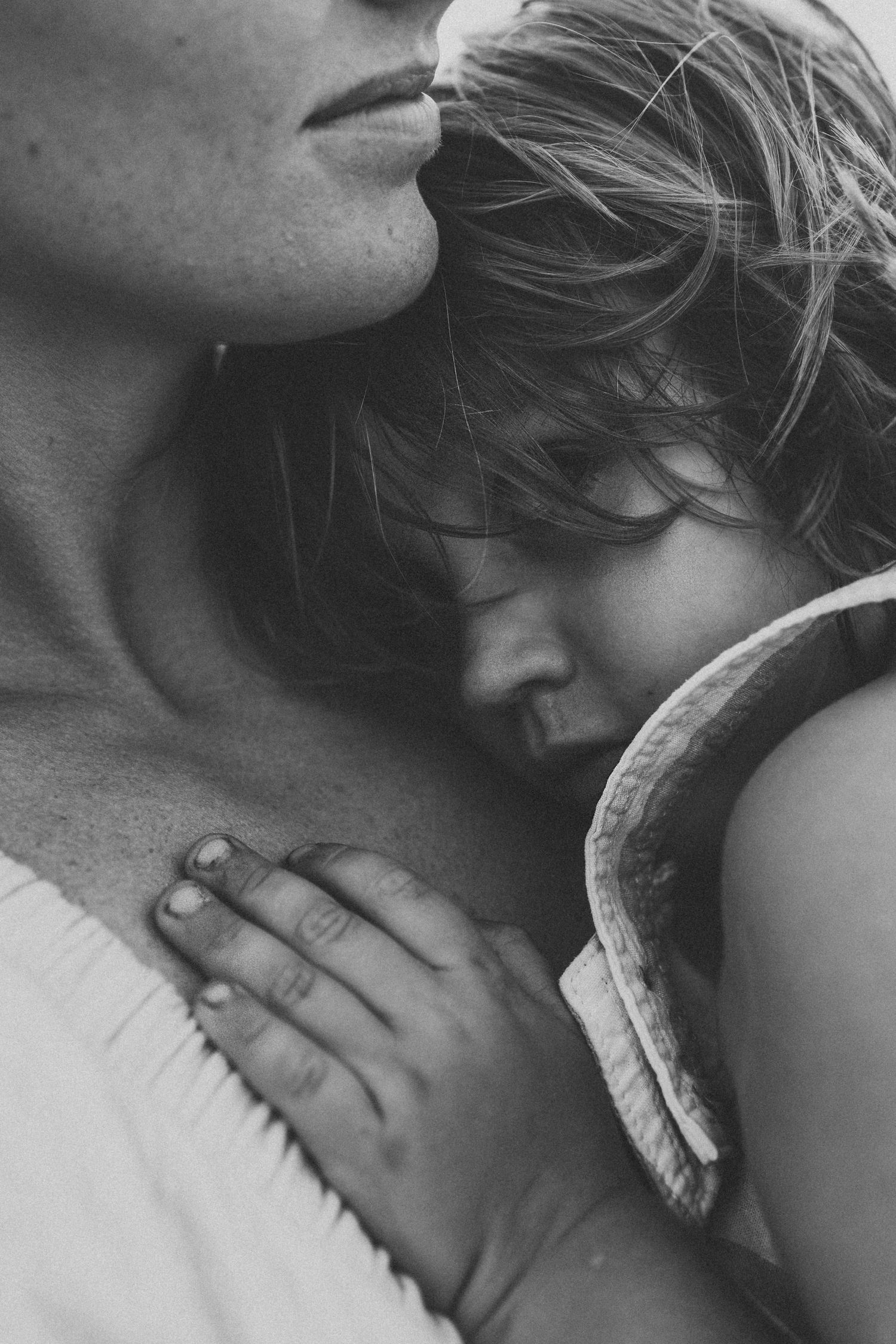 Emotional black and white photo of mom embracing kid by Maui photographer.