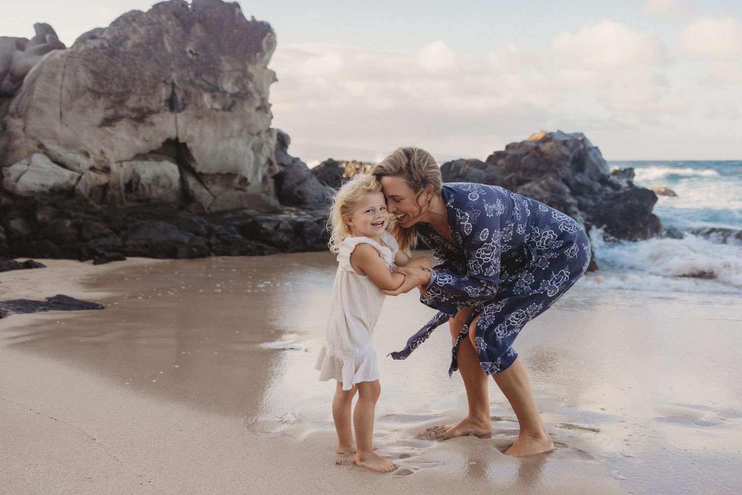 Maui family photography of mom and daughter playing joyfully by the ocean.
