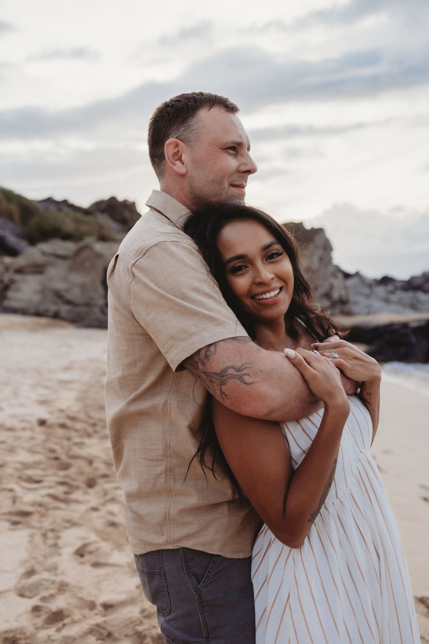 Maui couples photography of a couple standing by the ocean facing out to sea.