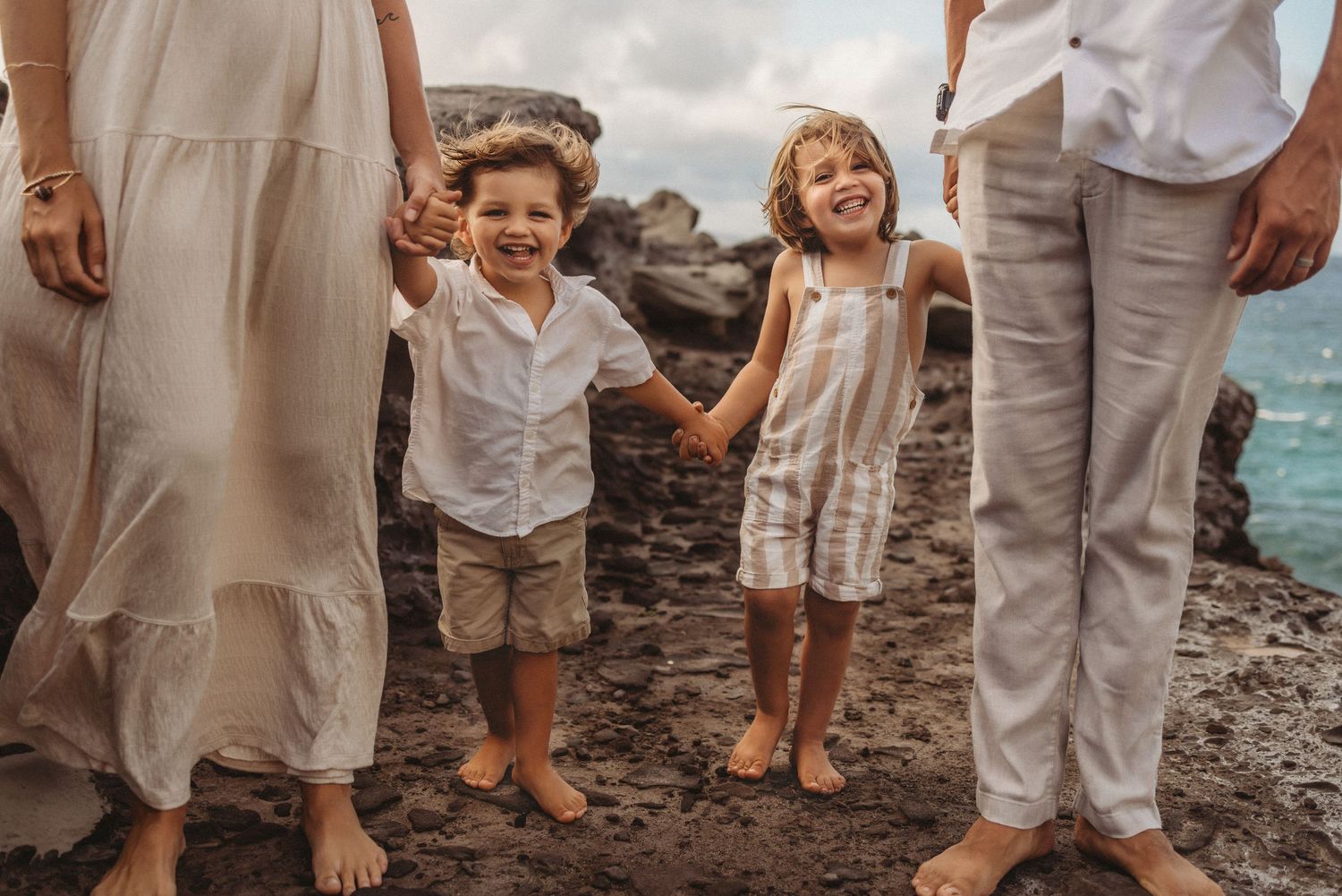 Maui family photography of two brothers standing between their parents on the beach.