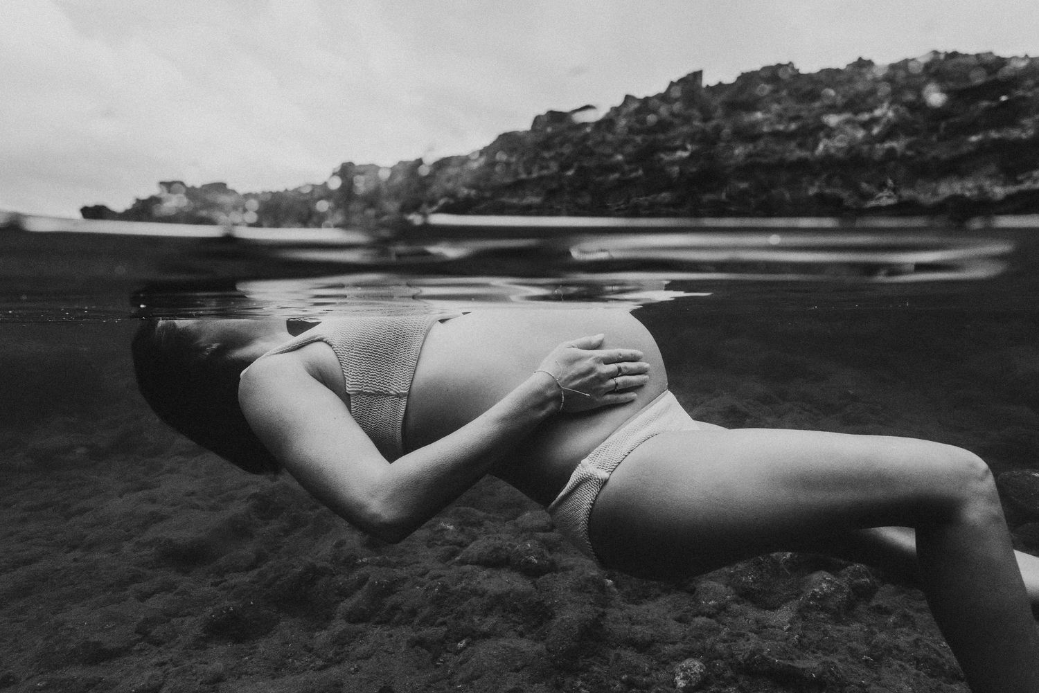 Artistic Maui portrait of expecting mother captured in an underwater scene.