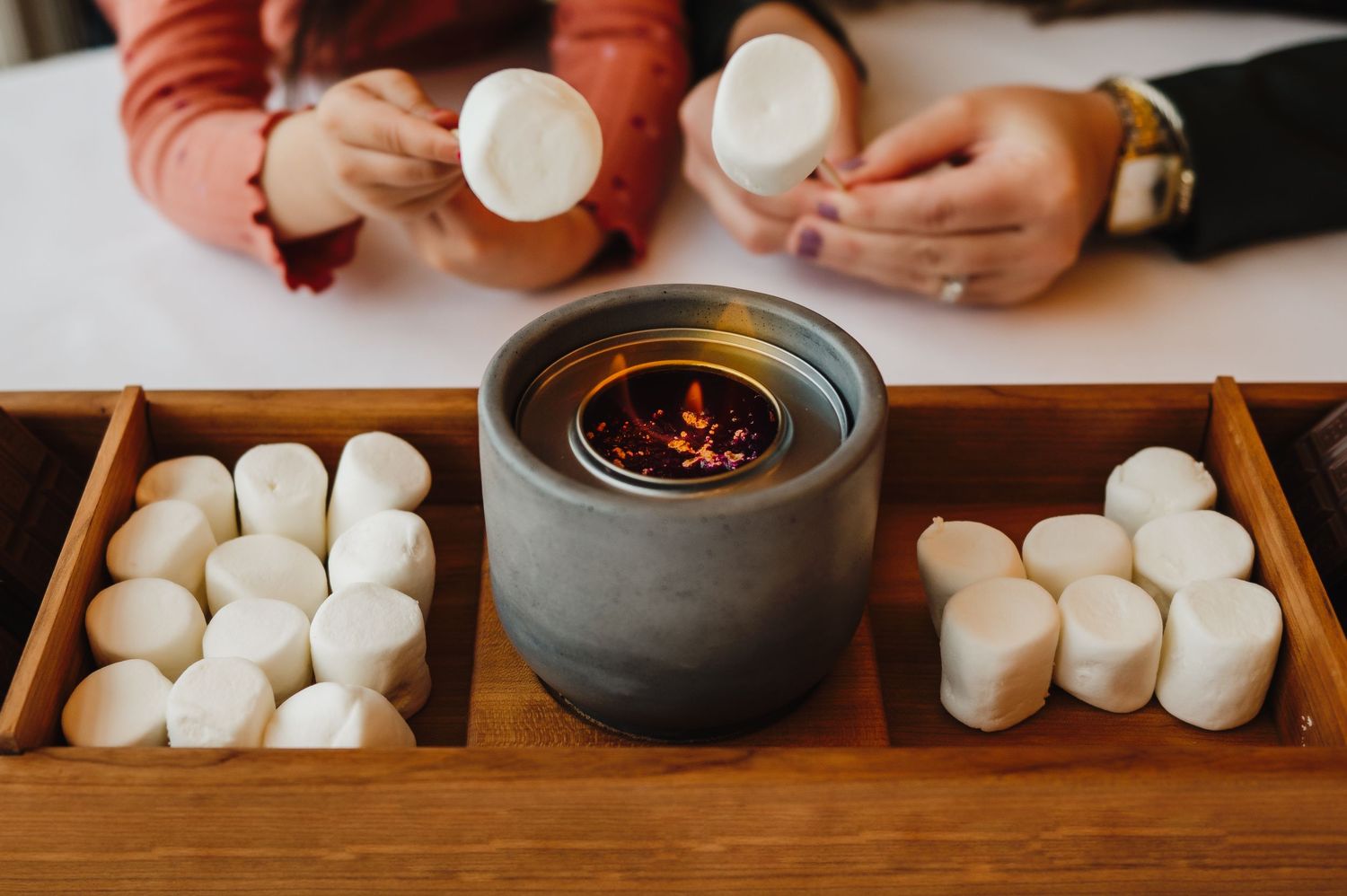id and mom sharing a cozy moment while toasting marshmallows.