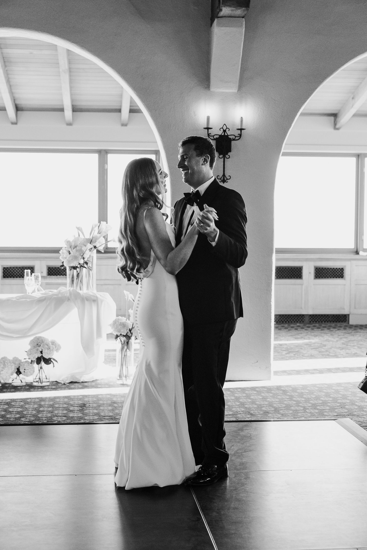 A romantic first dance moment under an arched doorway at an elegant wedding reception.