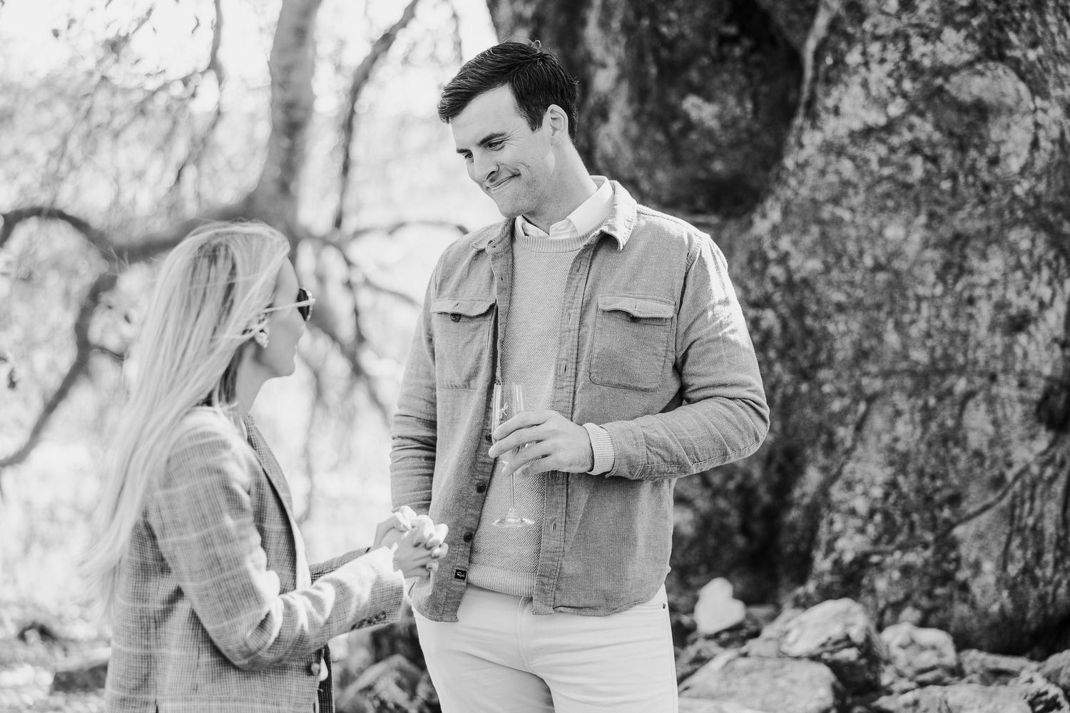 Romantic couple spending time together in a natural outdoor setting with dappled sunlight.