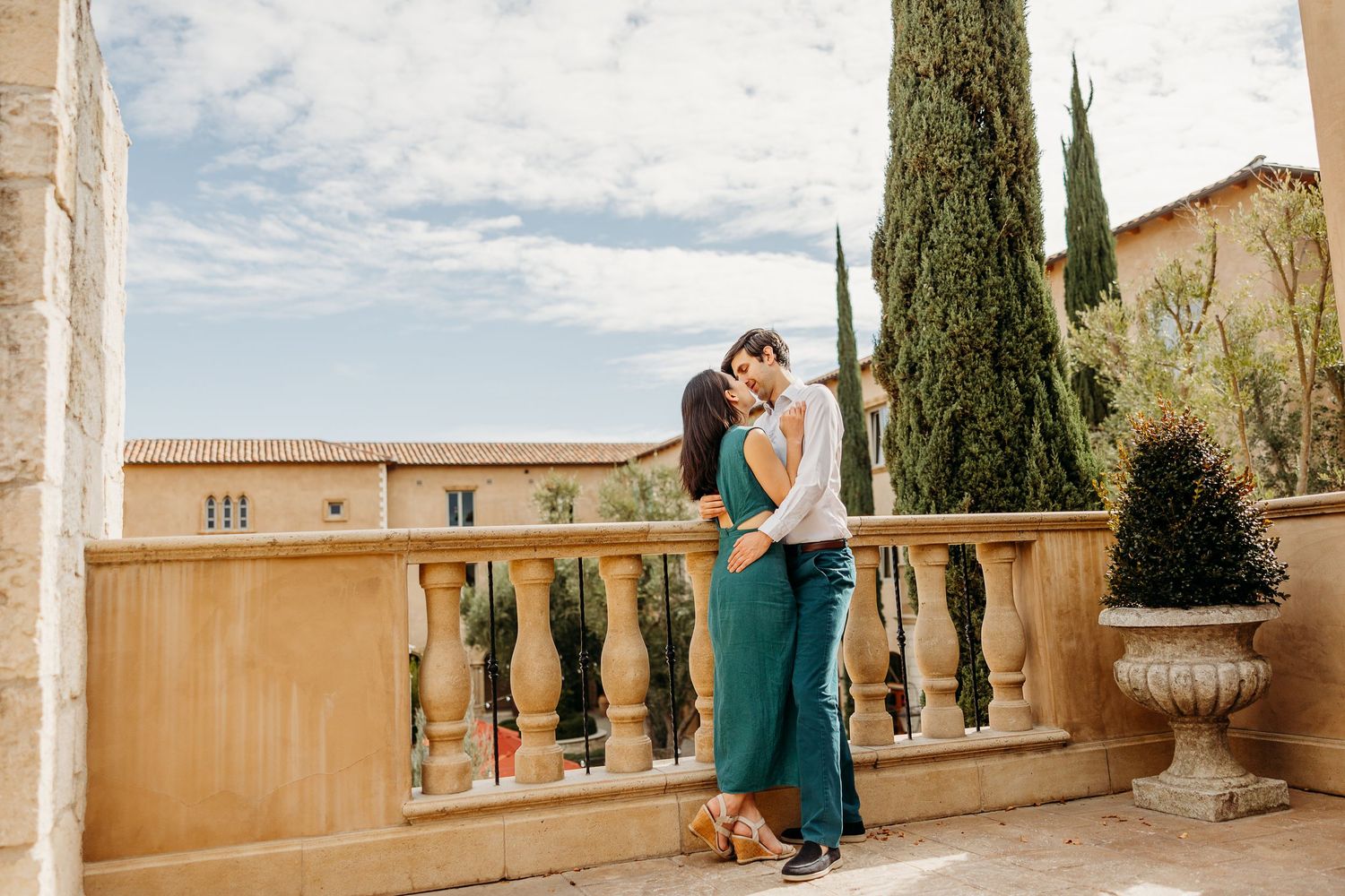 Romantic moment on Mediterranean style balcony with cypress trees in background.