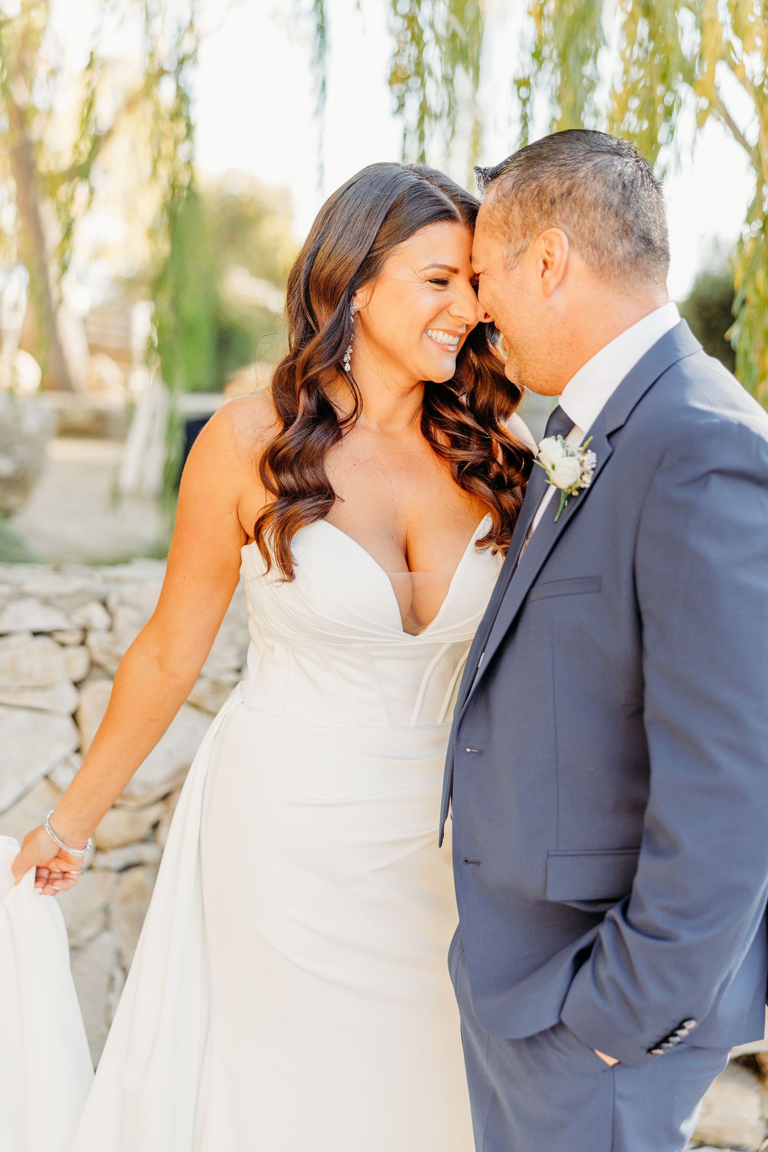 Close-up wedding photos capture intimate moments between couple under sunlit willow trees.