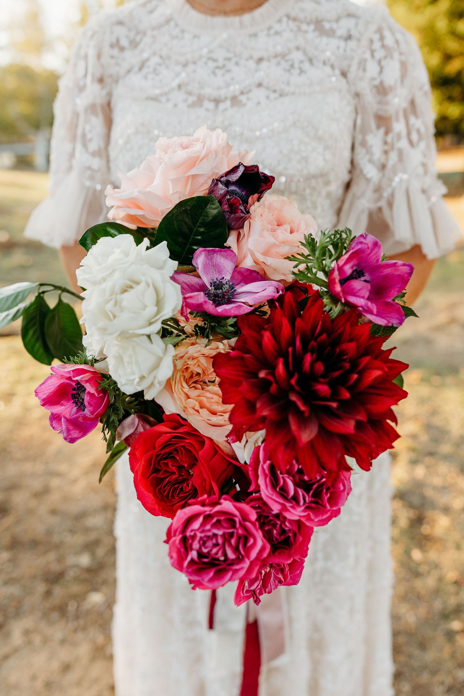 Beautiful bridal bouquet featuring deep red and pink flowers with white accents.