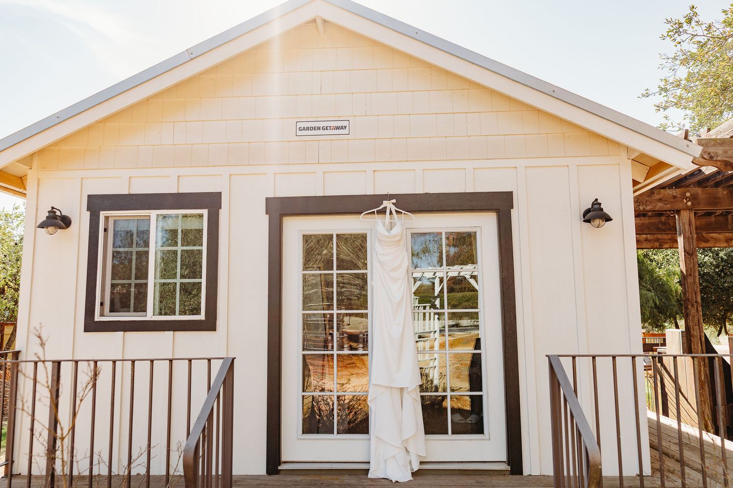 A modern white farmhouse exterior with black trim windows and sconce lighting mounted on the walls.